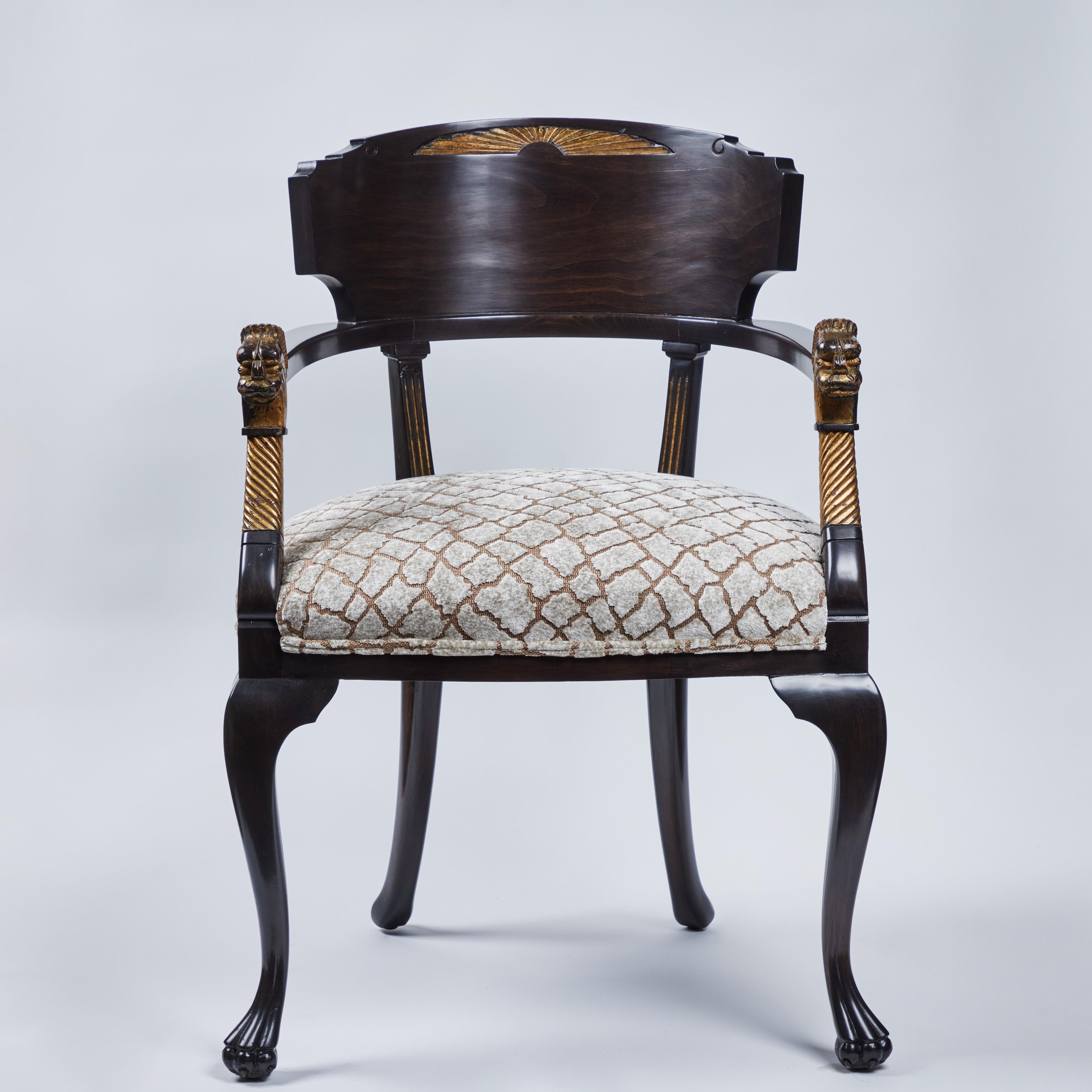 Striking accent chair in the Egyptian Revival style.  Lovely parcel gilt details at the arms and upper back.  Newly reupholstered in a chic, animal print from Romo.