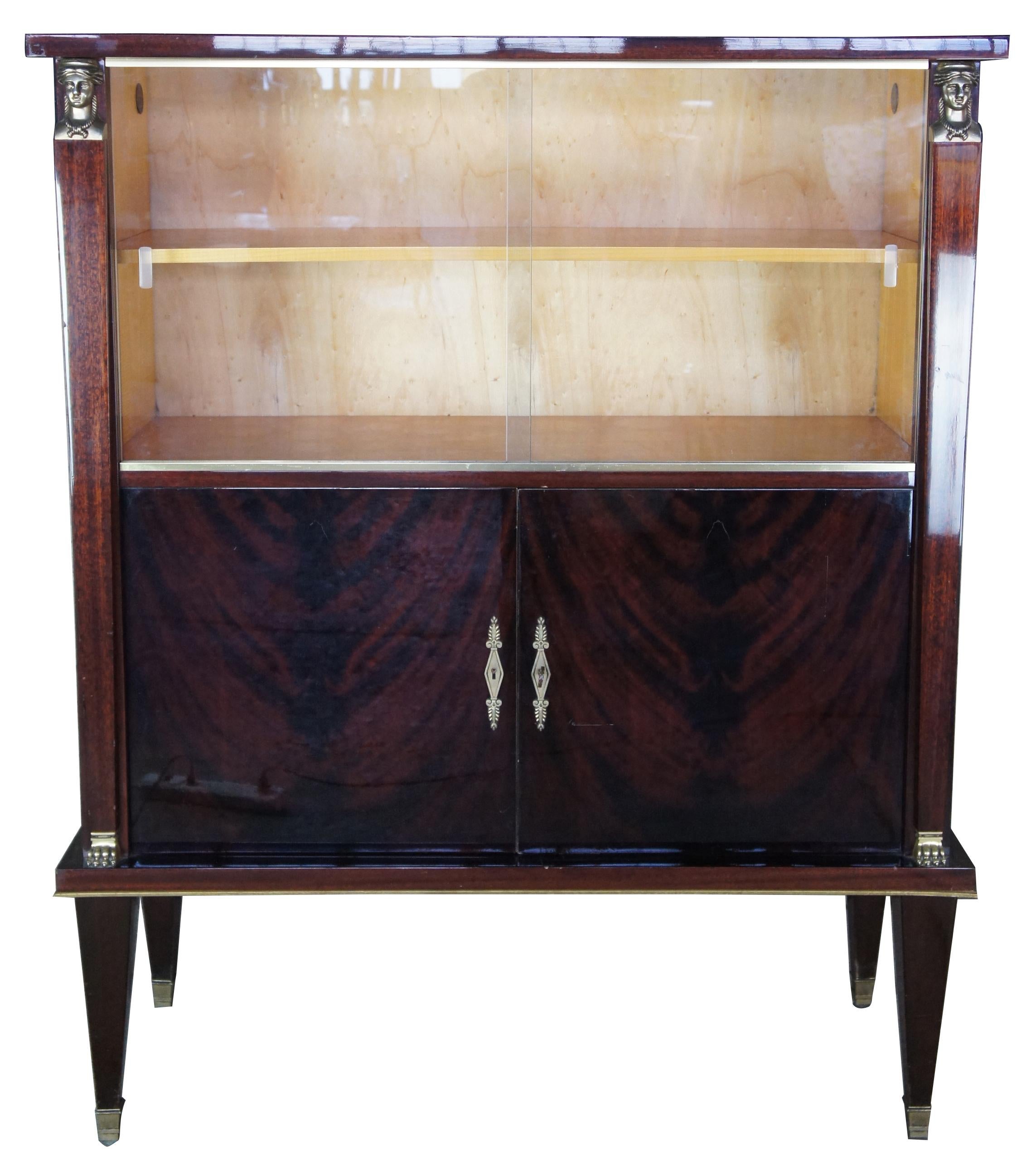 Egyptian Revival crotch mahogany and maple bar library bookcase Art Deco style

Egyptian Revival cabinet with bookshelves. Features mahogany with crotch front doors, great for use as bar back. Features figural brass mounts, glass doors, and maple