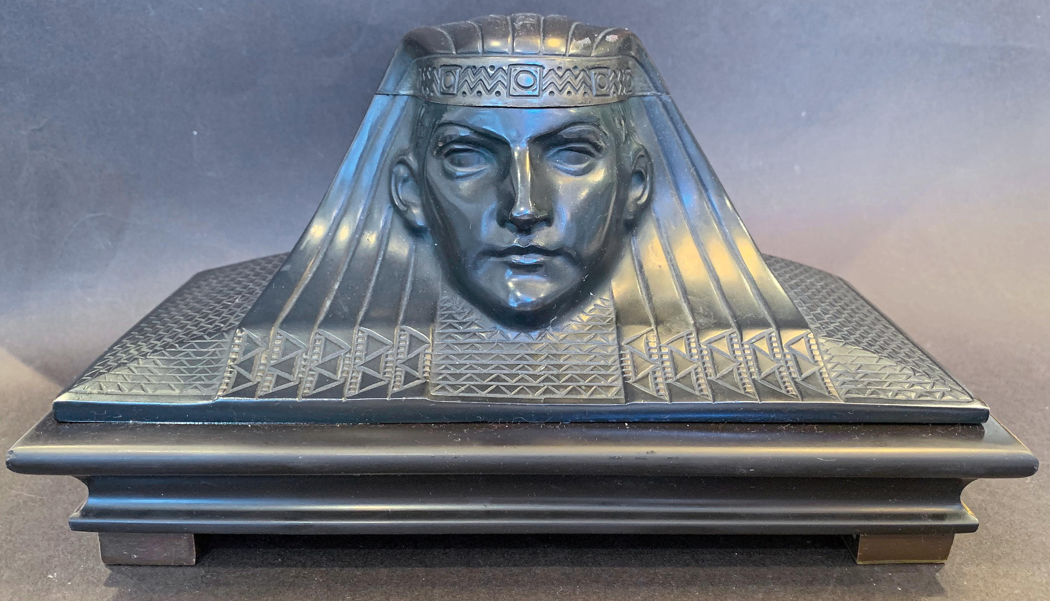 This magnificent bronze desk set -- including a large inkwell in the form of a Pharaoh's head, accompanied by a rocking blotter, paperweight and letter opener, each with Pharaoh or sphinx motifs -- is highly unusual, and may be unique. The quality
