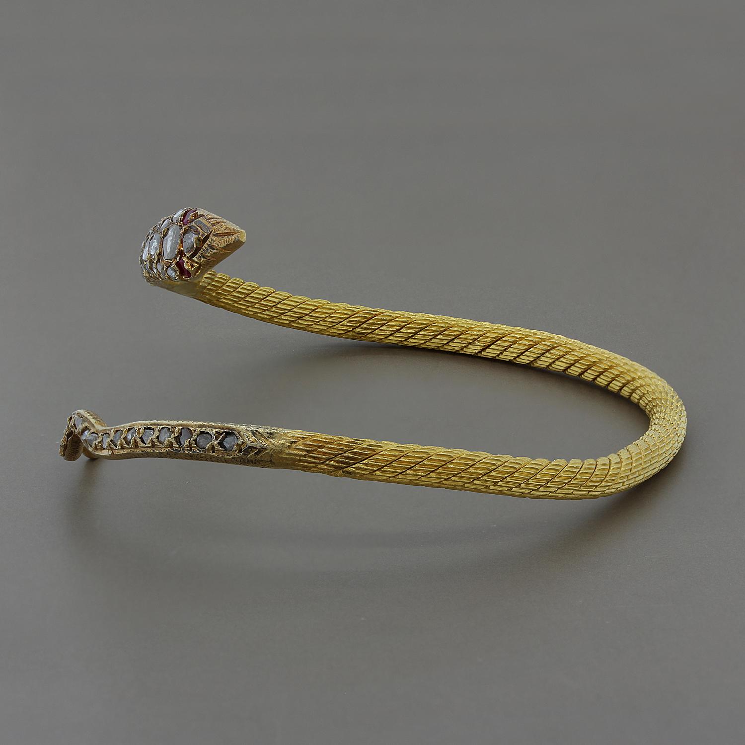 A snake cuff made in the early 20th century with rose cut diamonds and ruby eyes set in 18K yellow gold. Can be worn around the wrist or higher up around the arm.  It is from the Egyptian Revival era.

Fits writs up to 7 inches