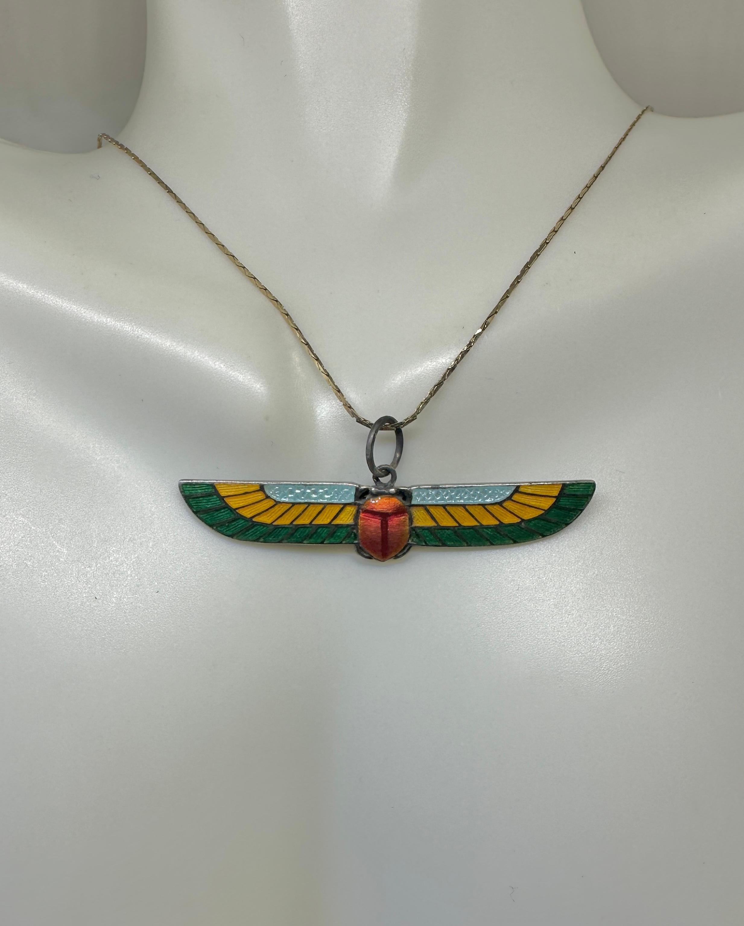 Indulge in a rare antique Art Deco Egyptian Revival Pendant Necklace of a Winged Scarab Insect done in gorgeous iridescent enamel and Sterling Silver.  The fabulous pendant depicts a winged Scarab beetle, one of the signature motifs of the Egyptian