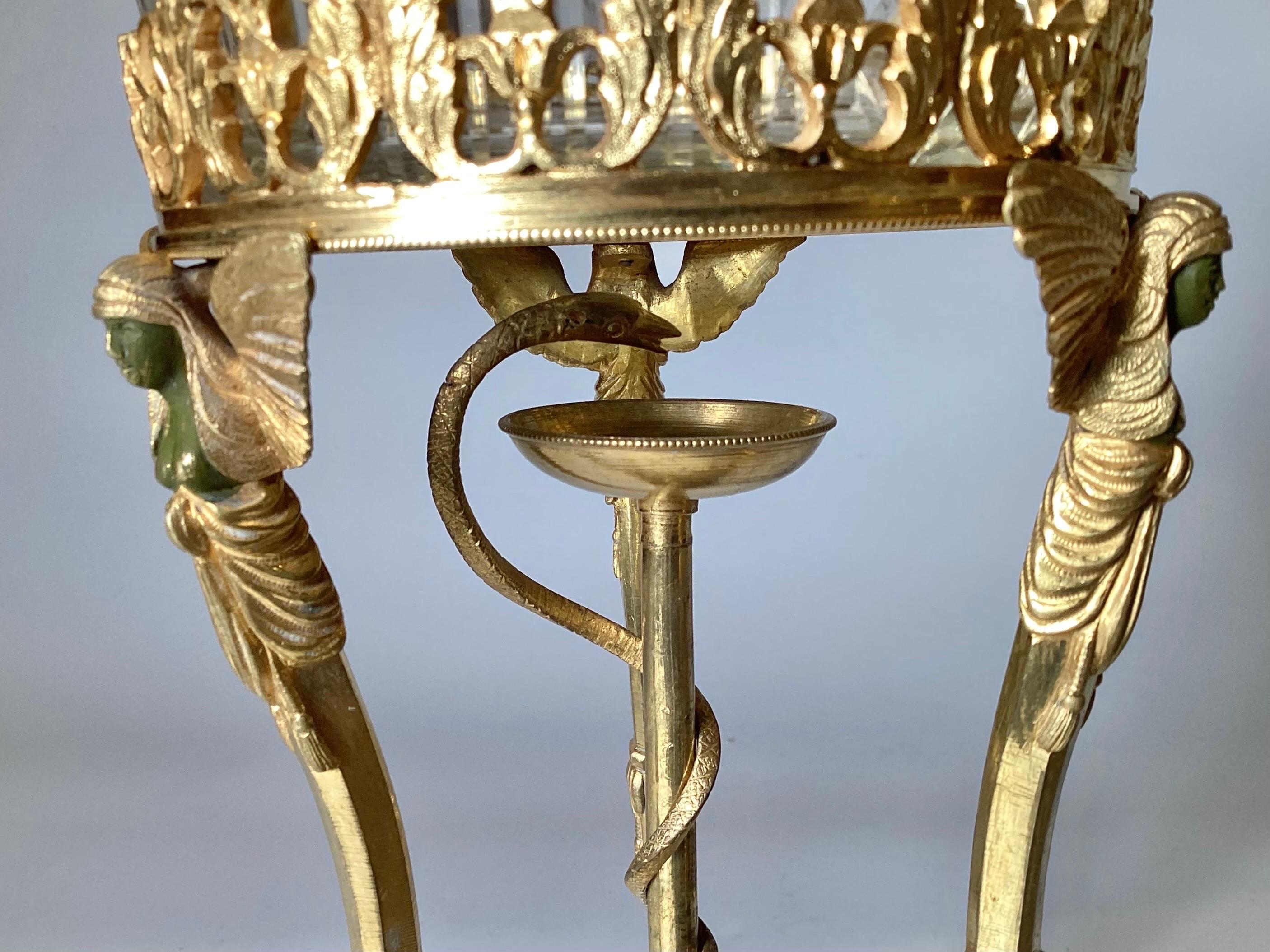 A round cut glass and bronze Egyptian revival pedestal compote.  The original gilt surface, with caryatid figures with patinated face.  The flared cut glass bowl fits perfectly at the top .  Made in Europe, Probably France, 1870's 12 inches tall, 8