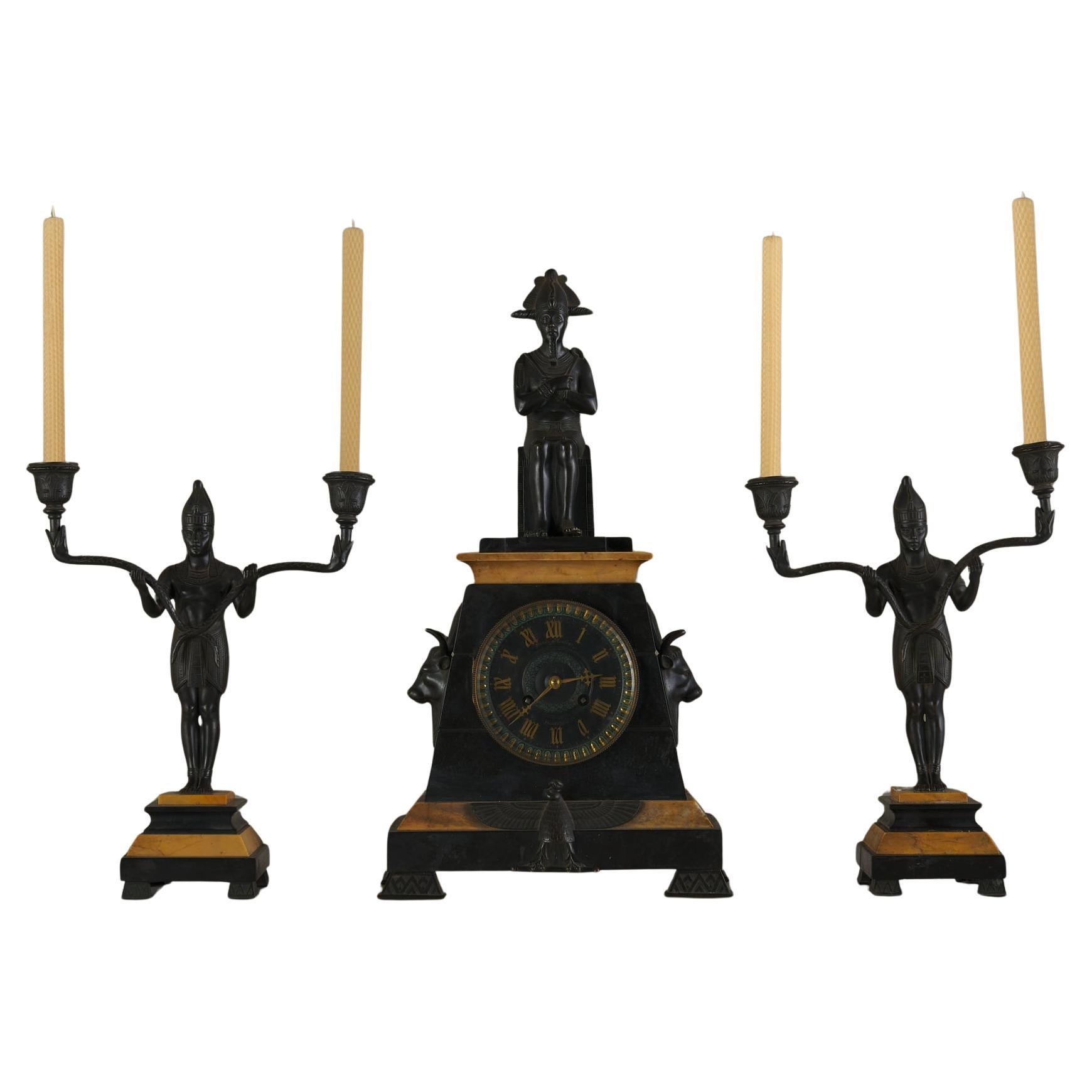 Orologio in marmo di epoca egiziana con due grani candelabri