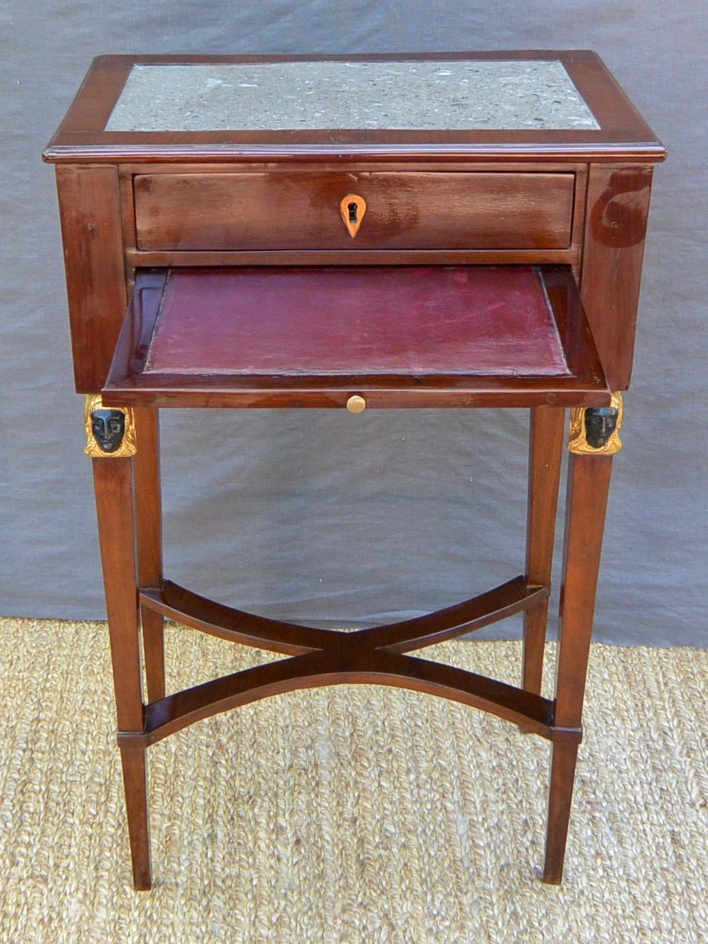 Table en marbre de style néo-égyptien. Table de chevet italienne retour d'Egypte à deux tiroirs avec écritoire et plateau en marbre de Sicile avec fossiles, le tout reposant sur des pieds effilés ; avec clé de verrouillage. Sicile, vers 1790.