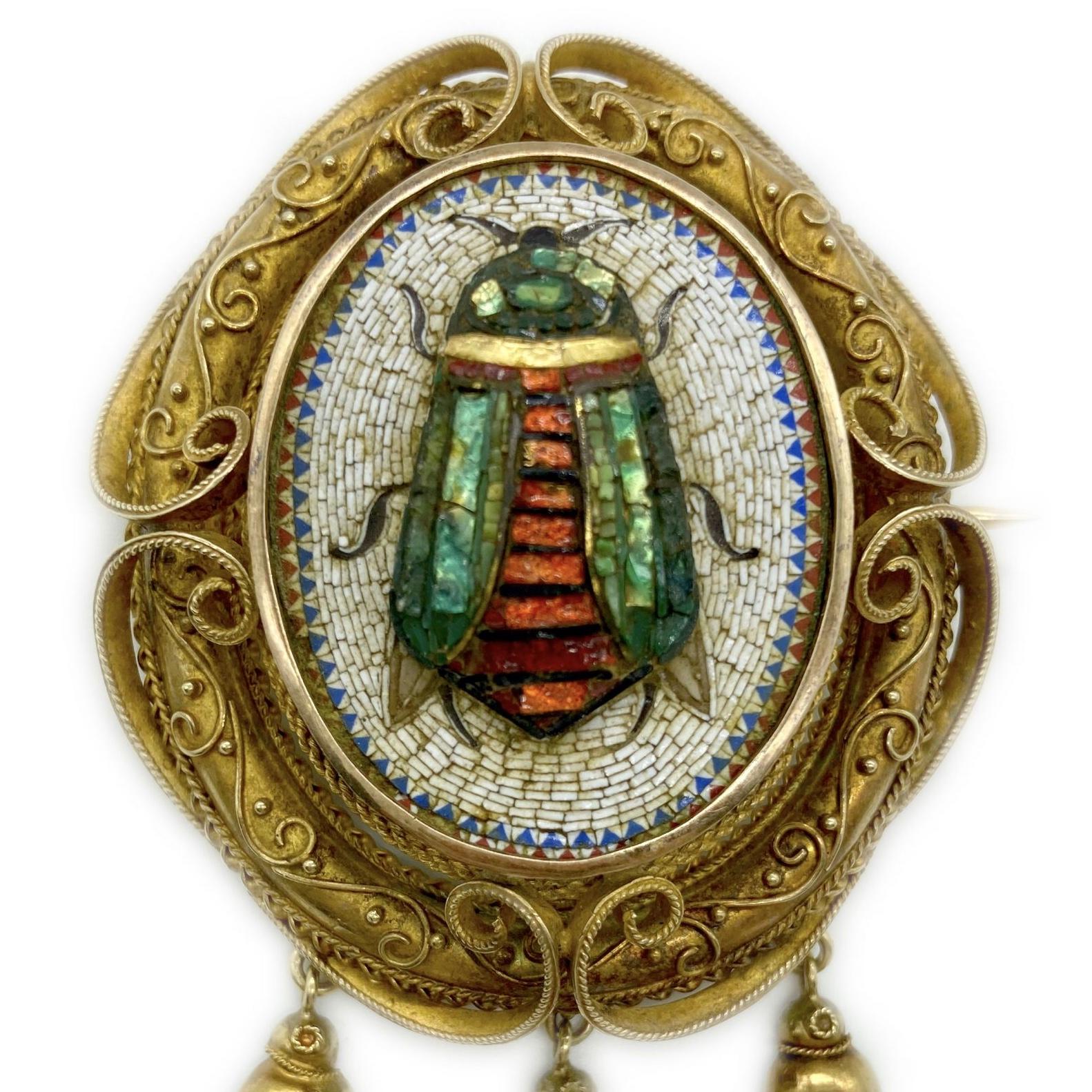 An antique yellow gold and micromosaic pendant-brooch depicting a scarab, which symbolized immortality and rebirth in Ancient Egypt. The granulation and goldwork is in the Egyptian revival style, inspired by the archaeological finds of the late