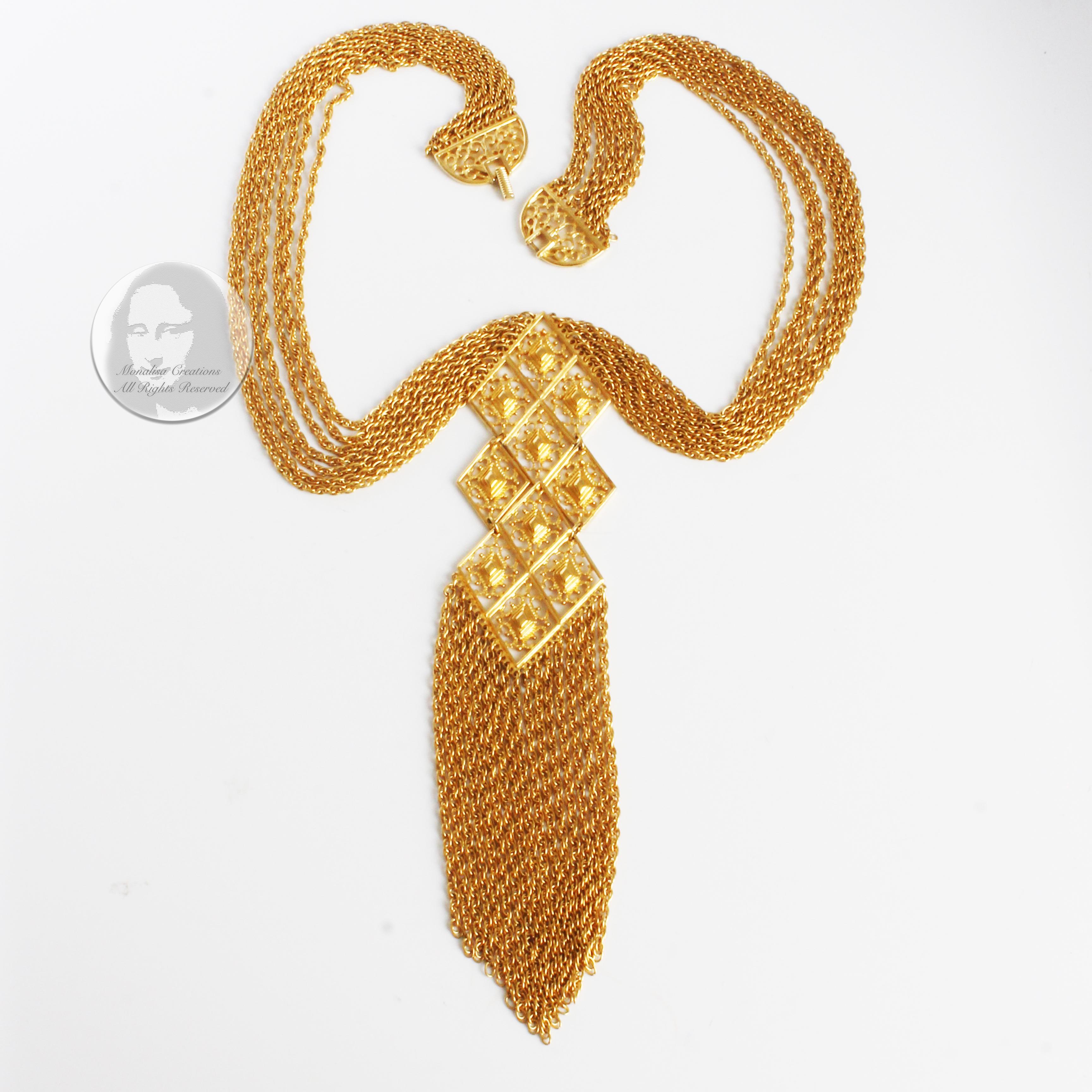 Preowned, vintage Egyptian revival style necklace, made by Goldette NY, most likely in the late 60s.  Made from multiple chain link strands, it features an articulated gold metal pendant with decorative diamond-shaped pieces and gold dangle fringe