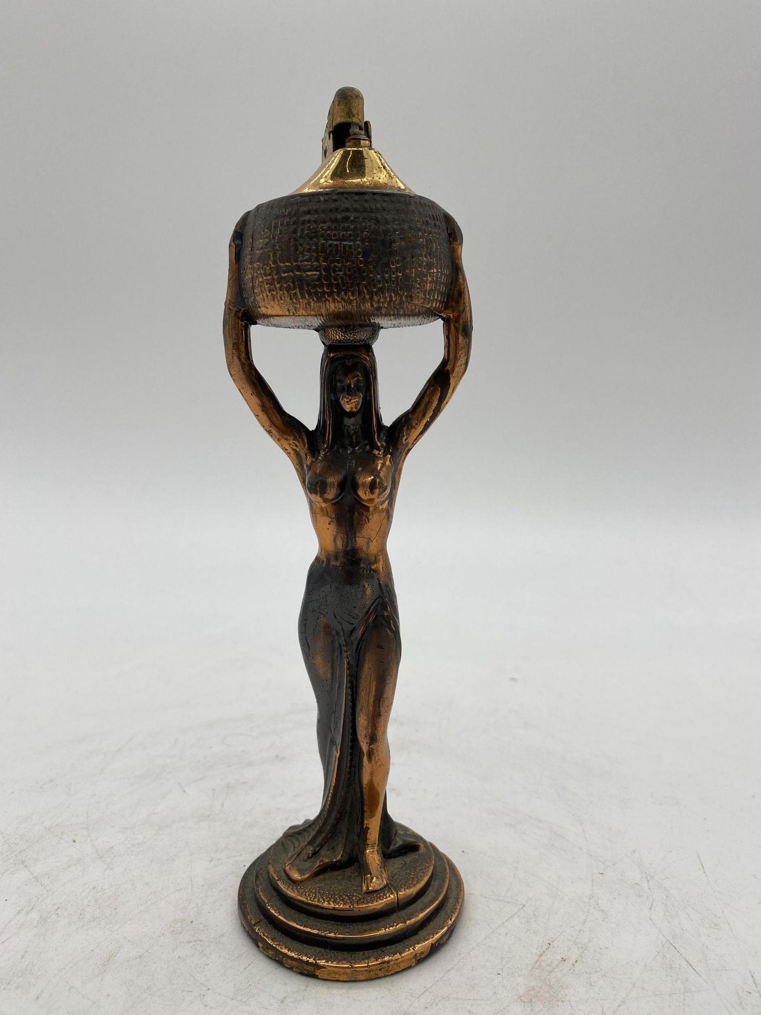 Art Deco era copper Egyptian Revival nude queen Table Lighter featuring a figural lighter with a removable lighter at the top.
1920, United States, comes empty and ready for use.