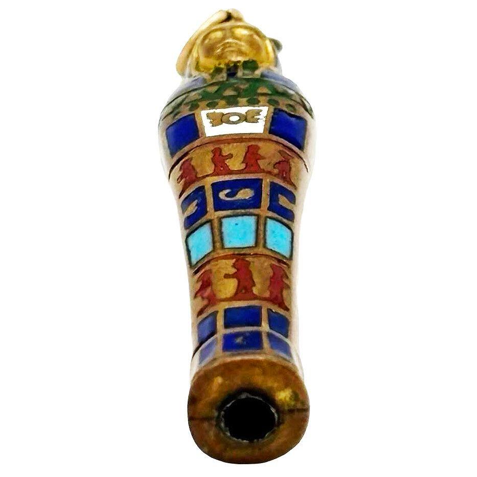 This vintage Egyptian revival retractable gilt pencil pendant features the shape of a Pharaoh's Sarcophagus. The pendant is crafted to resemble a miniature writing tool, often adorned with enameled hieroglyphic-like details or motifs inspired by the