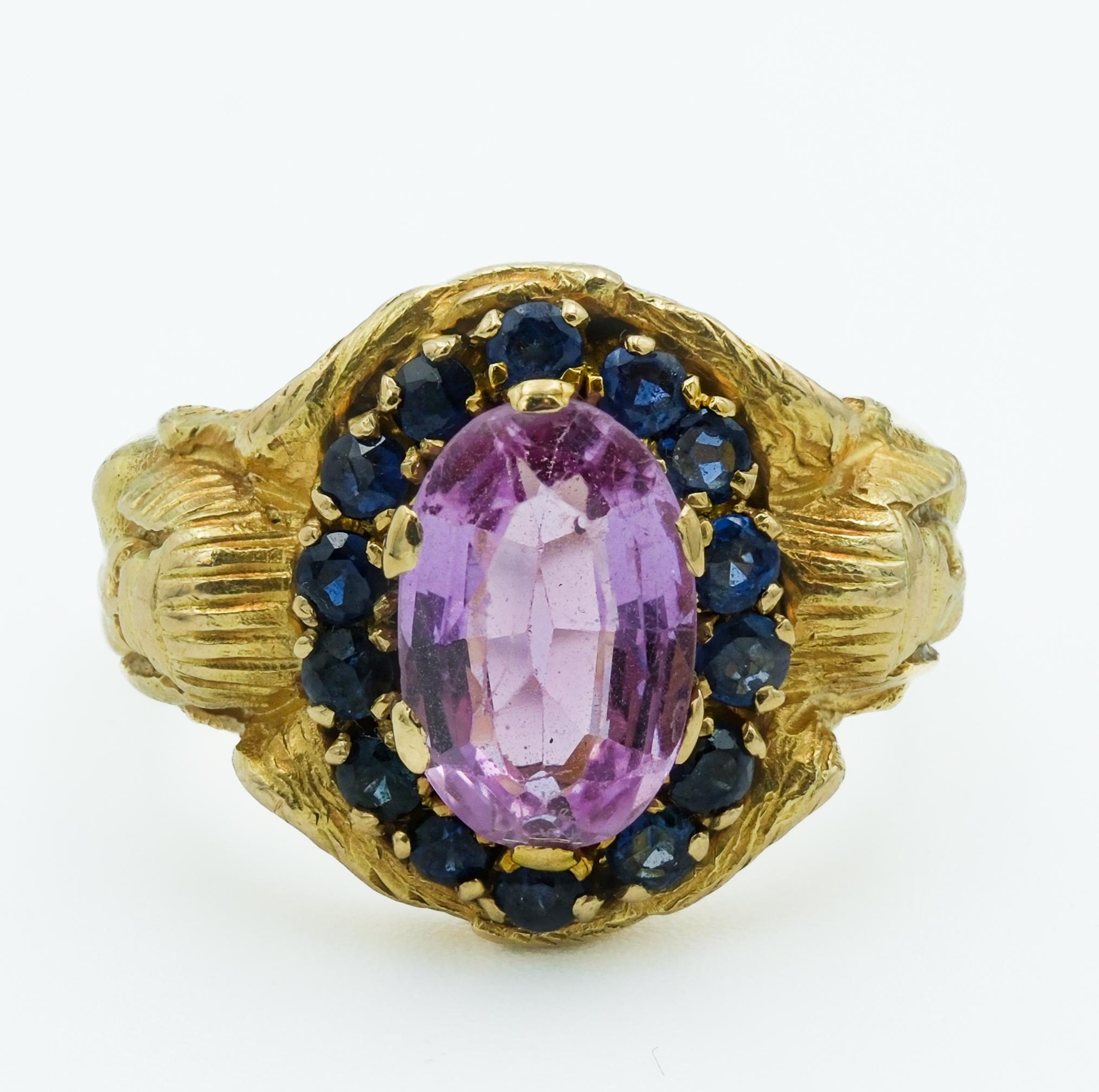 This ring is a notable representation of the Egyptian Revival jewelry, intricately crafted from 19-karat gold, a standard indicative of Portuguese artisanship. The ring features with a sizable 2.8-carat pink topaz, faceted cut to maximize its