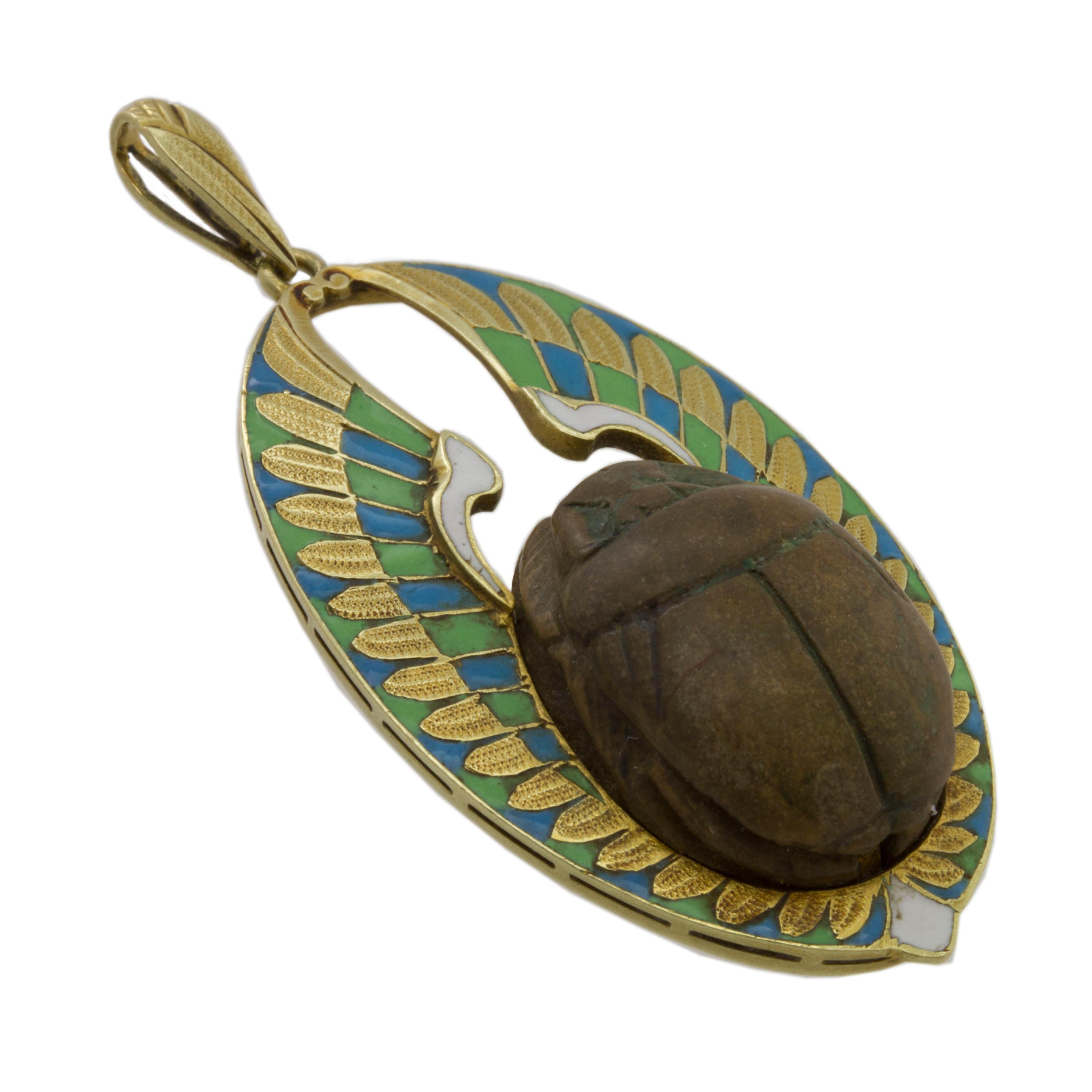 A Victorian scarab pendant, the Egyptian steatite scarab set within a yellow gold and enamel wing surround, marked 15ct gold, circa 1880, measuring approximately 4.9 x 2.3cm, gross weight 7.7 grams.

This antique pendant is in excellent condition.