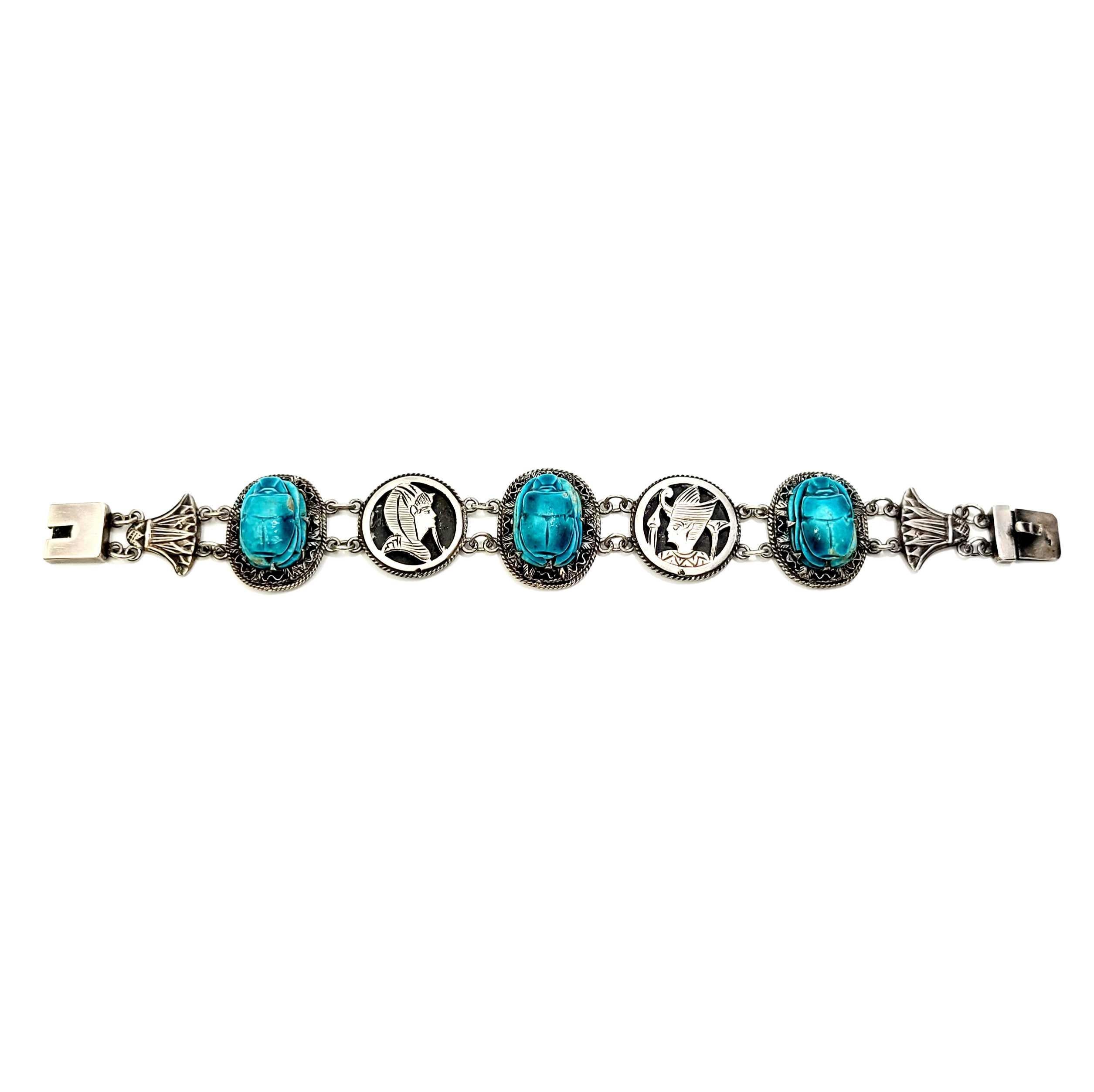 Silver Egyptian Revival scarab bracelet, c.1930s.

Popular in the 1930s, when King Tut's tomb was found, this example of an Egyptian Revival bracelet features 3 carved hand painted faience pottery oval beetles, alternating with King Tut