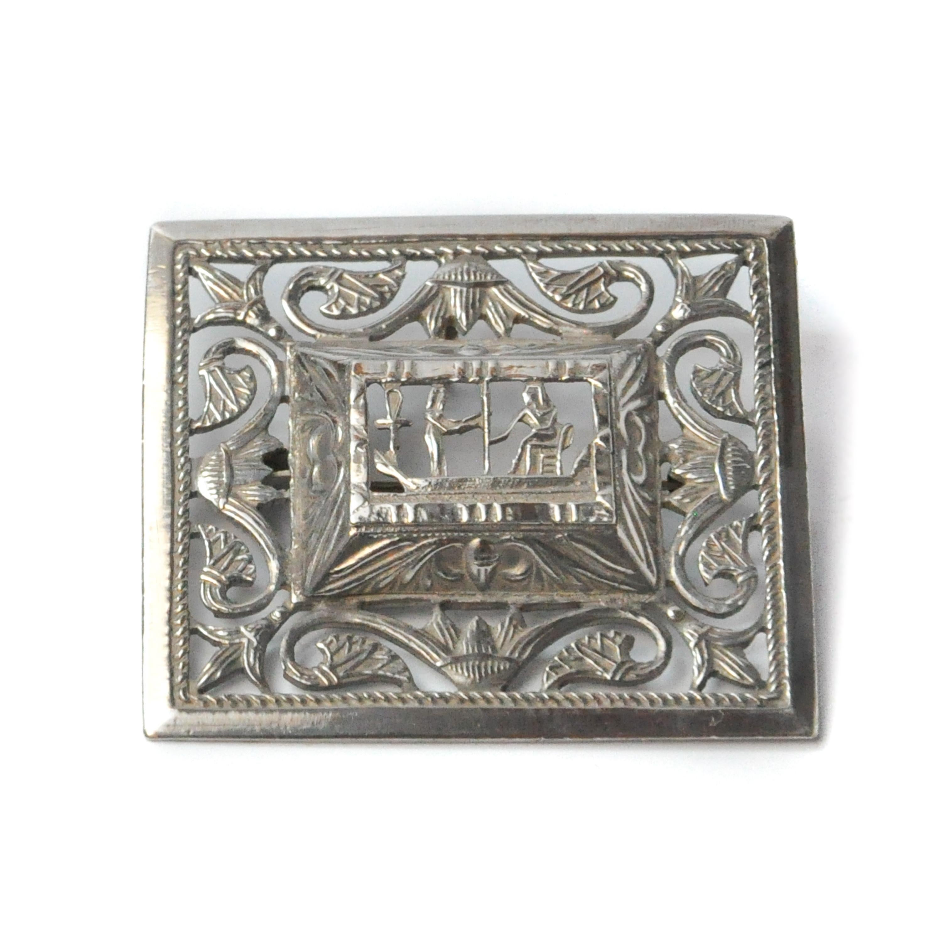 A vintage silver rectangular brooch with a cut out of an Egyptian hieroglyphic mythology scene. The scene depicted here is the worship of Osiris, as supreme deity of the dead, Osiris was the representative of the world order in the afterlife. Every