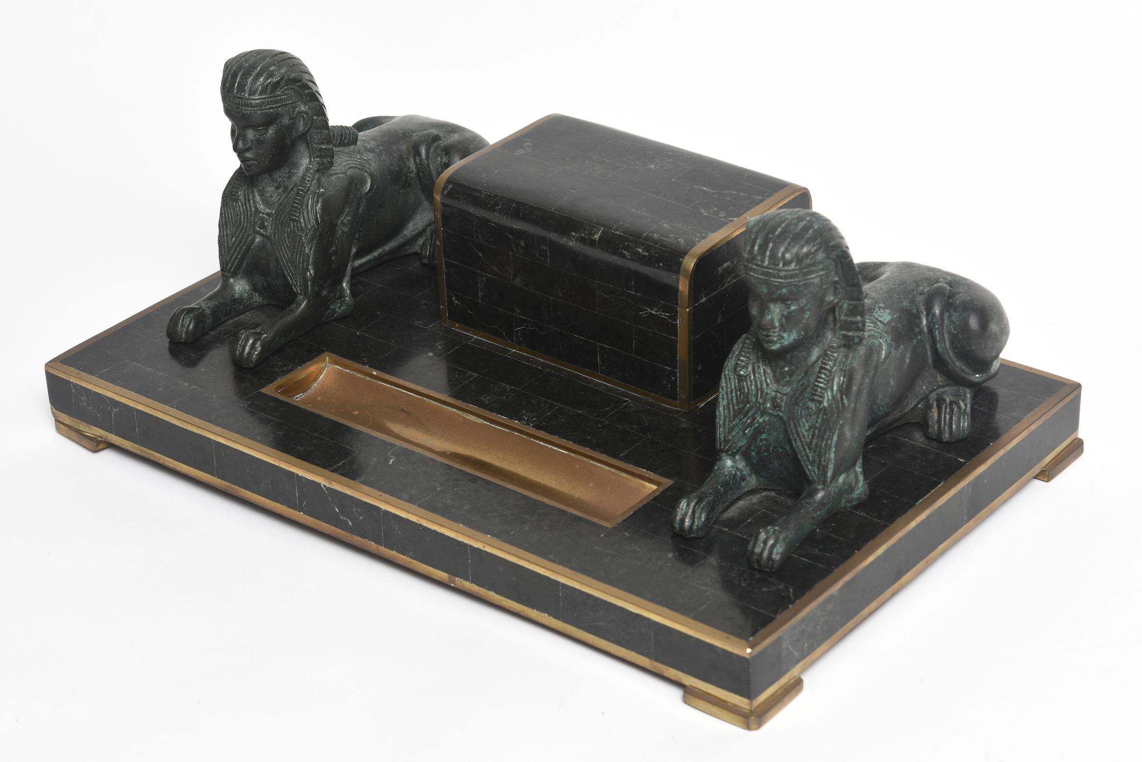 Maitland-Smith Egyptian Revival inkwell desk set featuring a tomb form stamp box with a sphinx mounted on either side. The front section has a recessed pen tray. The piece is made of tessellated black marble and brass.

 