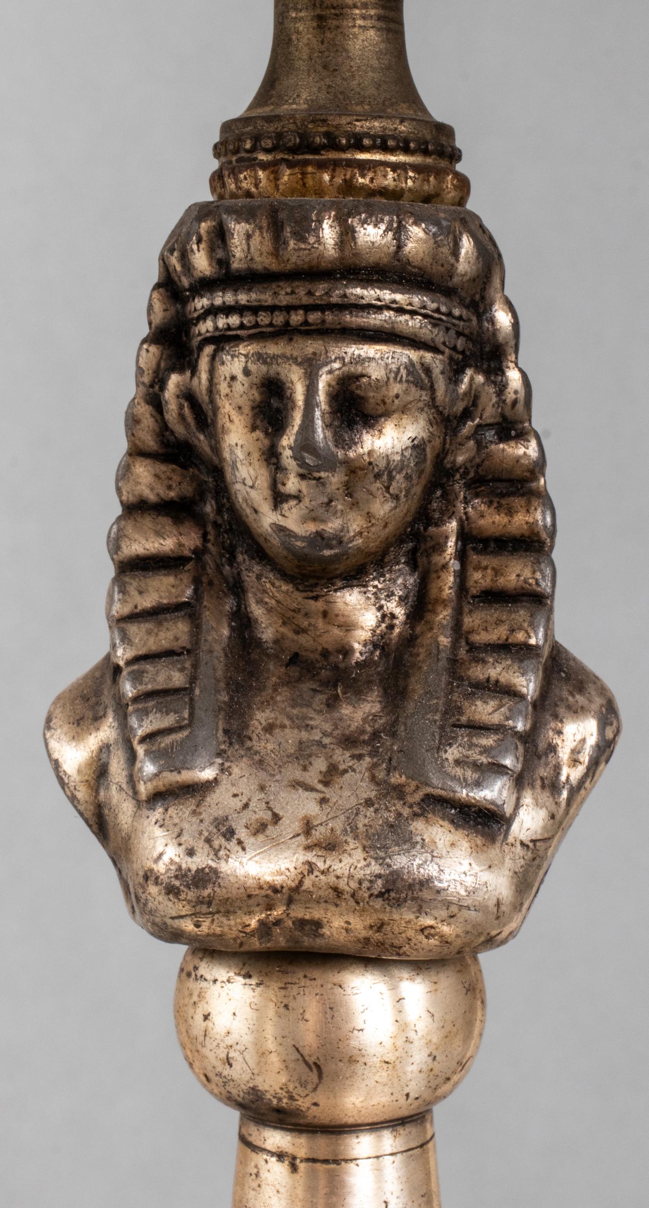 Lampe de table en aluminium de style néo-égyptien, abat-jour en tôle à quatre lumières sur des bras en forme de becs de lampe à huile, entourant un masque figuré d'un pharaon, la colonne standard dans une base en forme de plat renversé sur une base