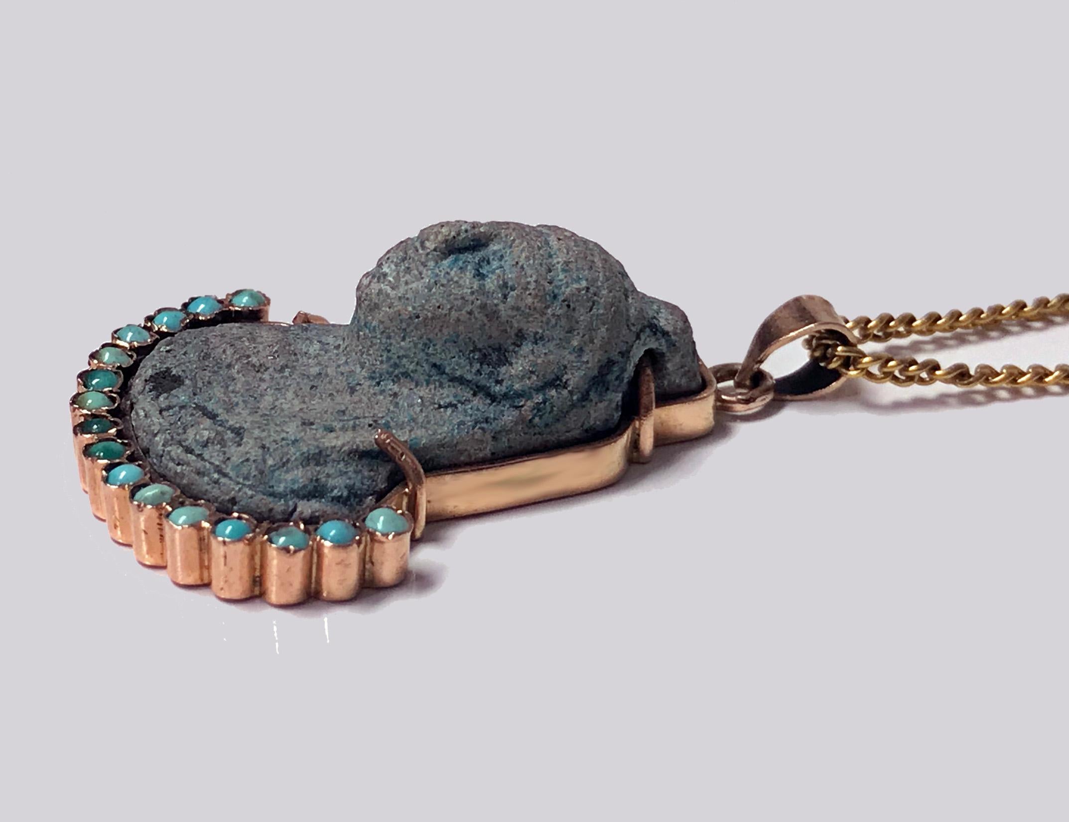 Egyptian revival carved Turquoise Gold  Pendant of a Pharaoh, C.1920. The carved turquoise Pharaoh set in 14K pink gold with turquoise stones collar conforming to lower neckline. The Pendant surmounted with gold bale. Egyptian marks to reverse, side