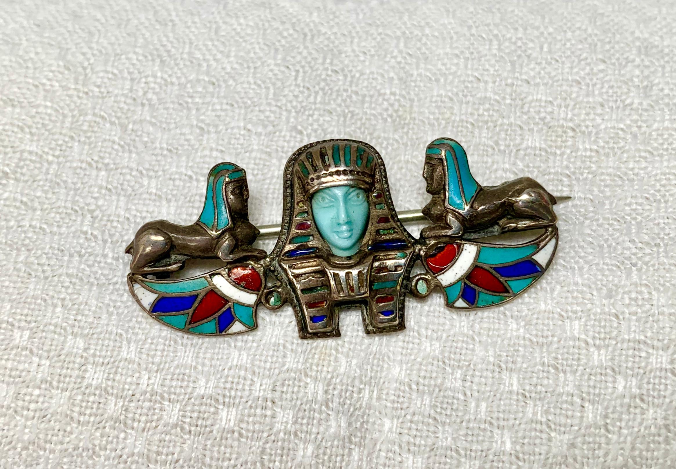 Un rare chef-d'œuvre de l'Art déco néo-égyptien.  Cette superbe broche est centrée sur la tête d'un pharaon dont le visage est magnifiquement sculpté à la main en turquoise persane.  La face turquoise reflète le travail d'un maître artisan.  Le