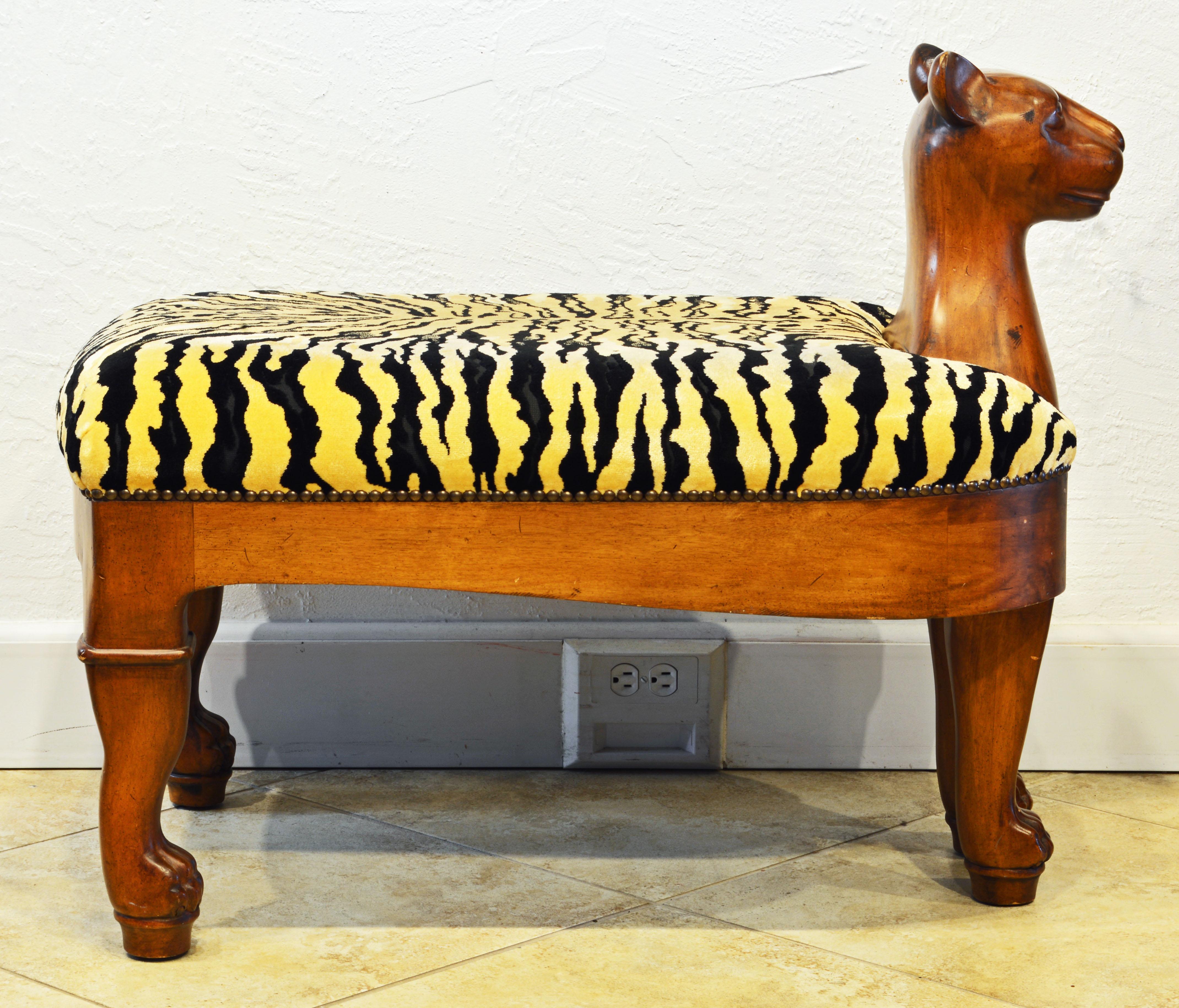 This unusual bench likely dates to the 1980s. It features a stylized lion in the Egyptian style supporting an upholstered seat covered with tiger print fabric.