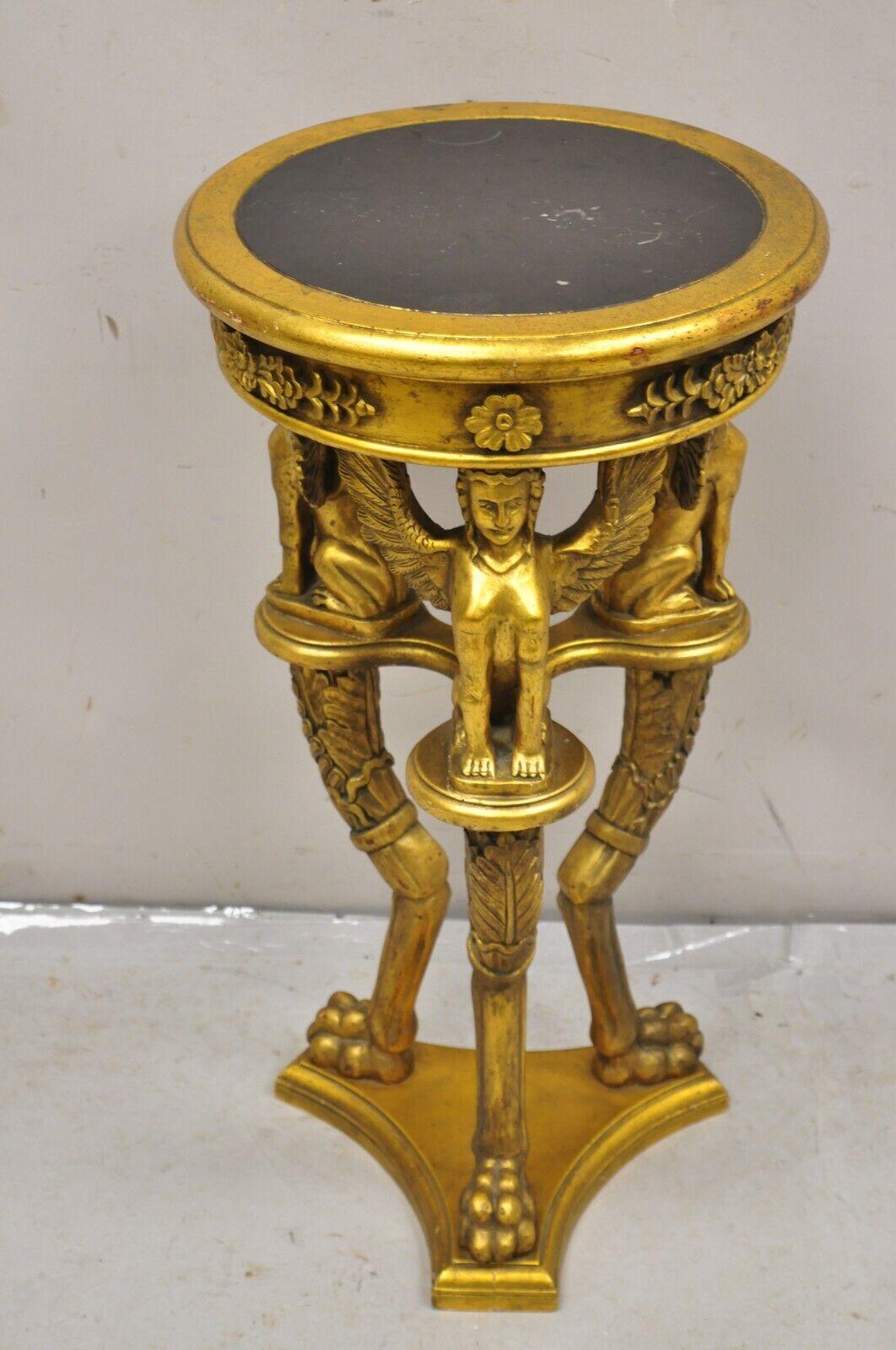 Egyptian Revival Style Gold Giltwood Round Marble Top Figural Pedestal Plant Stand. Item features tripod base with winged maiden figures and paw feet, very nice pedestal.  Circa Late 20th Century. Measurements: 30