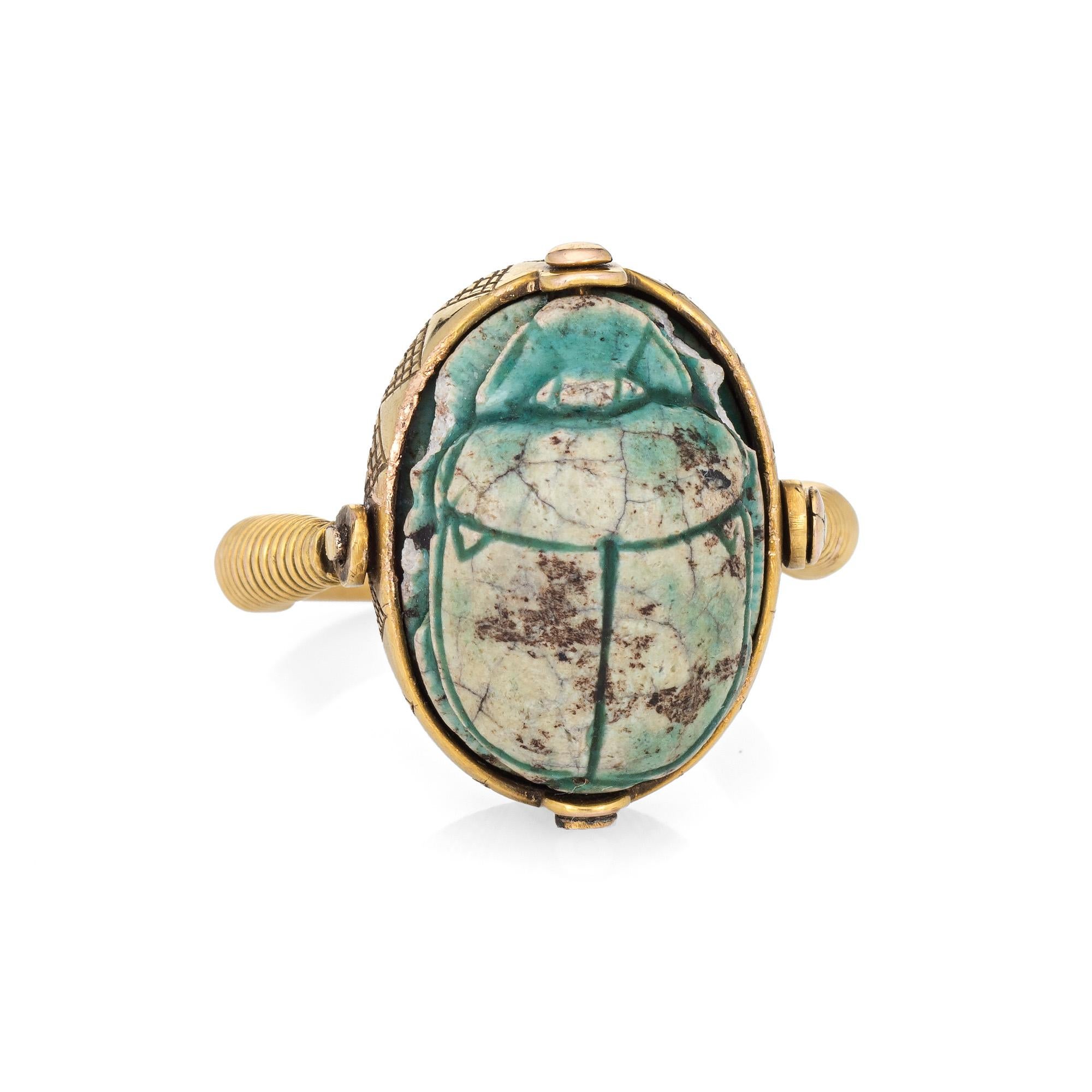 Ornate Egyptian scarab beetle ring (circa 1960s), crafted in 14 karat yellow gold. 

Centrally mounted green stone (Egyptian Faience) is hand carved in the form of a scarab beetle, a symbol of renewal and rebirth. Egyptian Faience is a non-clay