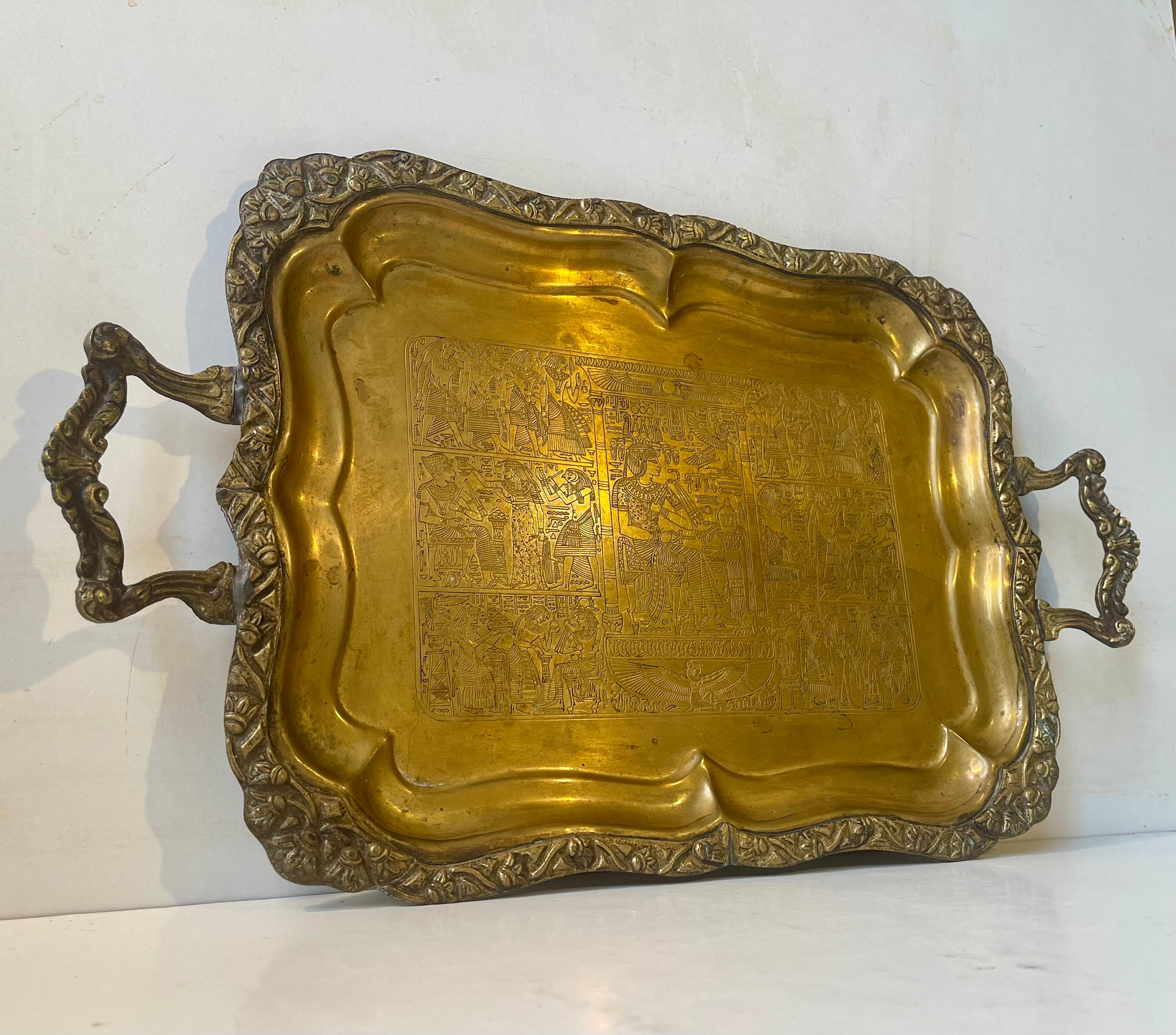 Hand-engraved Egyptian serving tray in brass. Imported as a souvenir to Denmark circa 1950-60. It features ornamented handles, hieroglyphs and pharaoh depictions. Measurements: L: 47 cm, H: 2-4 cm, W: 28 cm.

Free World wide express shipping.