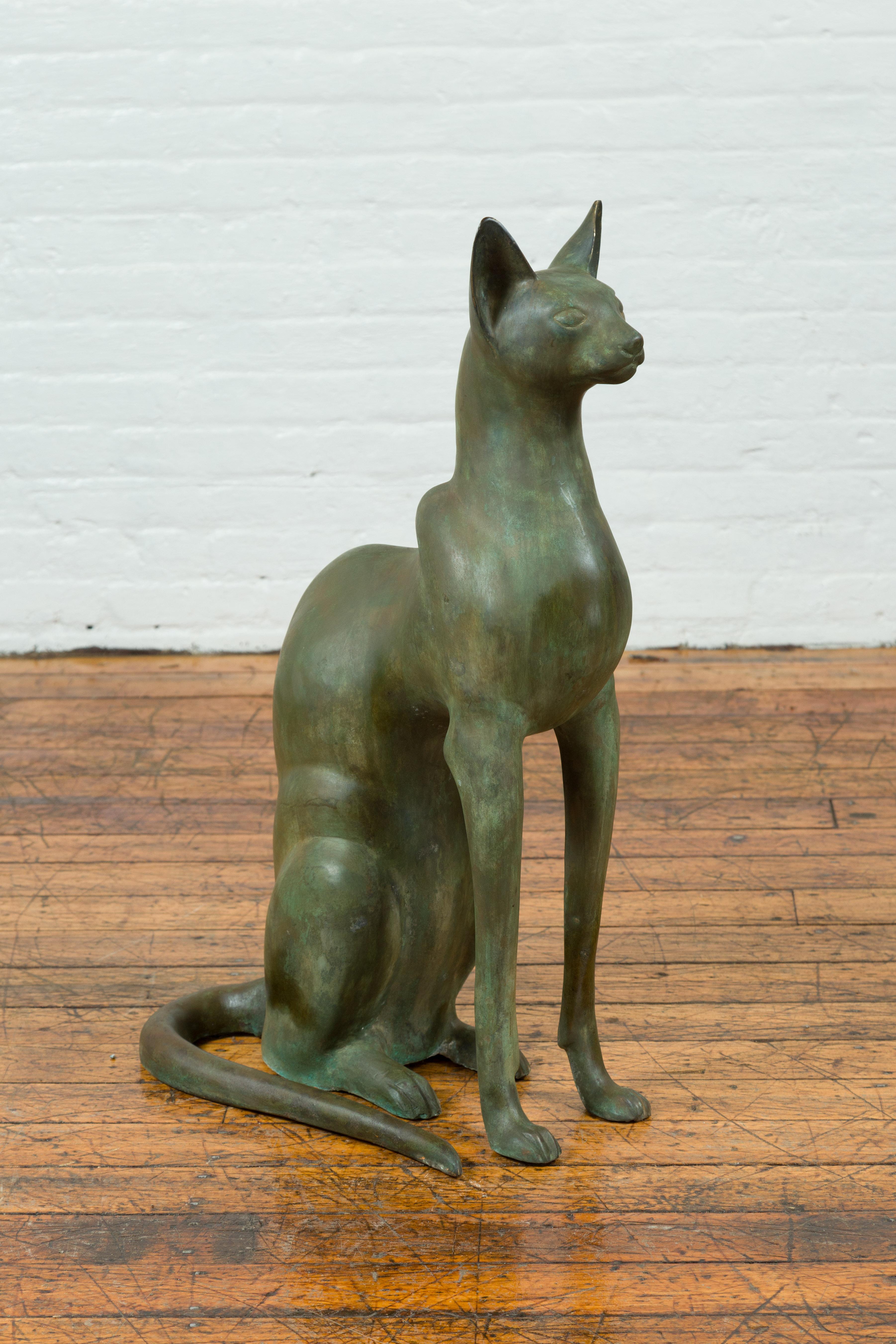 A bronze Egyptian style cat sculpture from the late 20th century. A perfect tribute to ancient Egypt's devotion for cats, this bronze sculpture draws us in with its dignified depiction of a cat measuring 31.5
