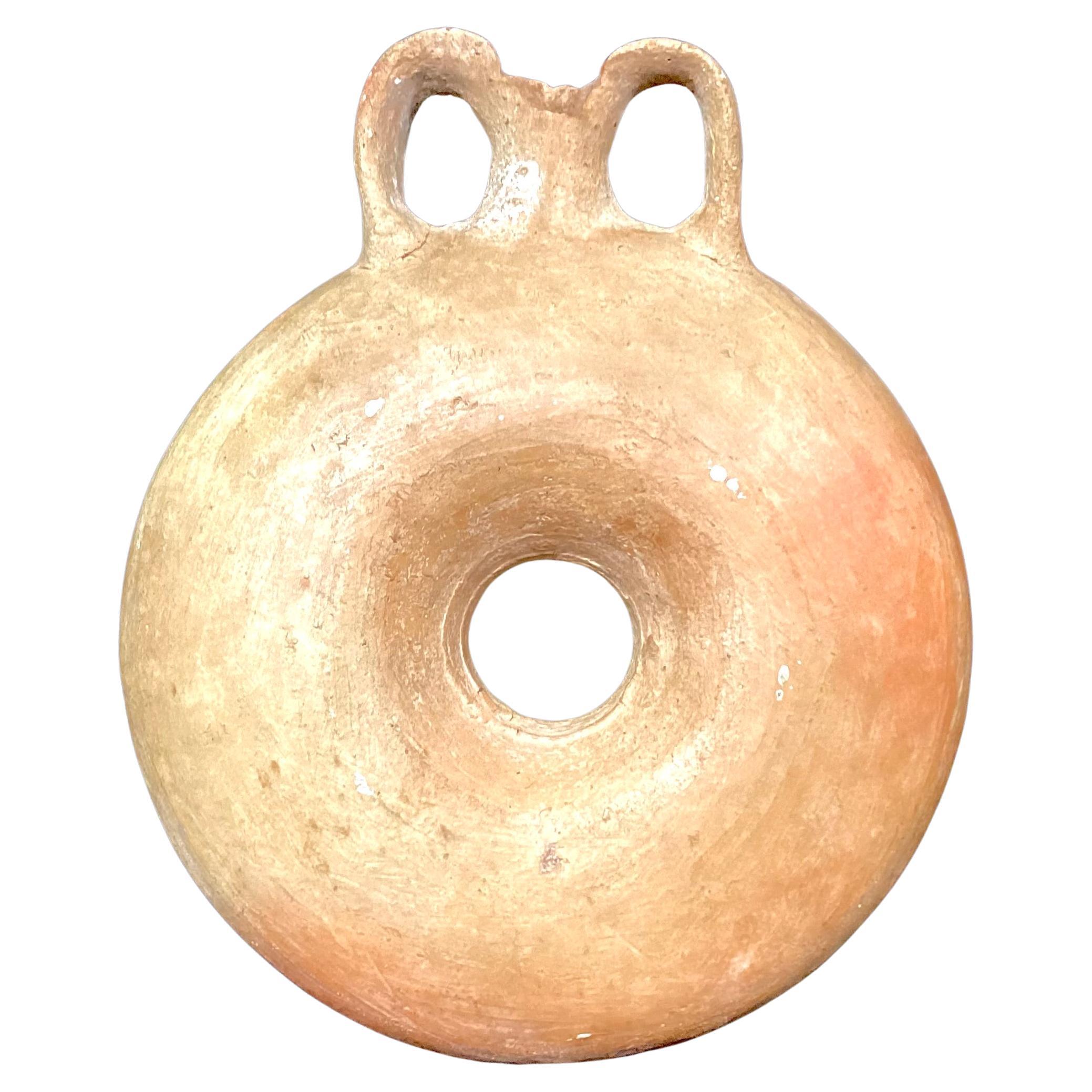 Antique Roman Terracotta Flask. Features a small, round container with a flask-like top with an small opening. These were also used to hold perfume and other personal care oils. The Aryballos were a common item in daily Roman life, including the