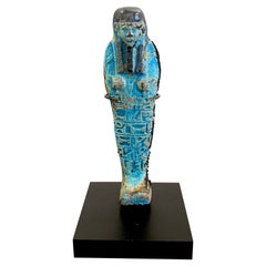Shabti egiziano di faience turchese, montato in museo