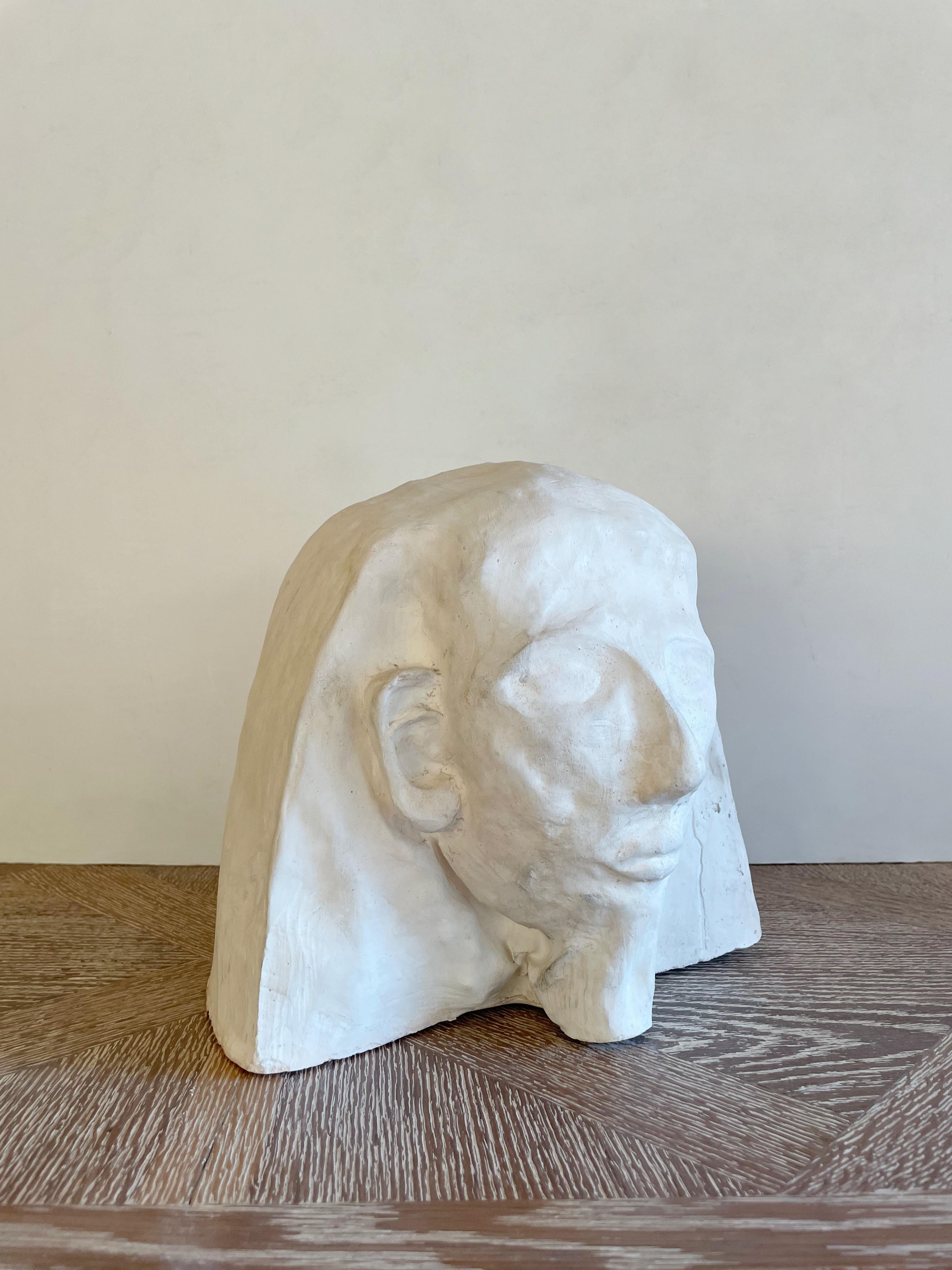 Unsigned, this heavy white head plaster sculpture conveys a majestic impression thanks to the skillful combination of curved and sharp lines.
The back of the head features a deep slash which may be the artist signature.