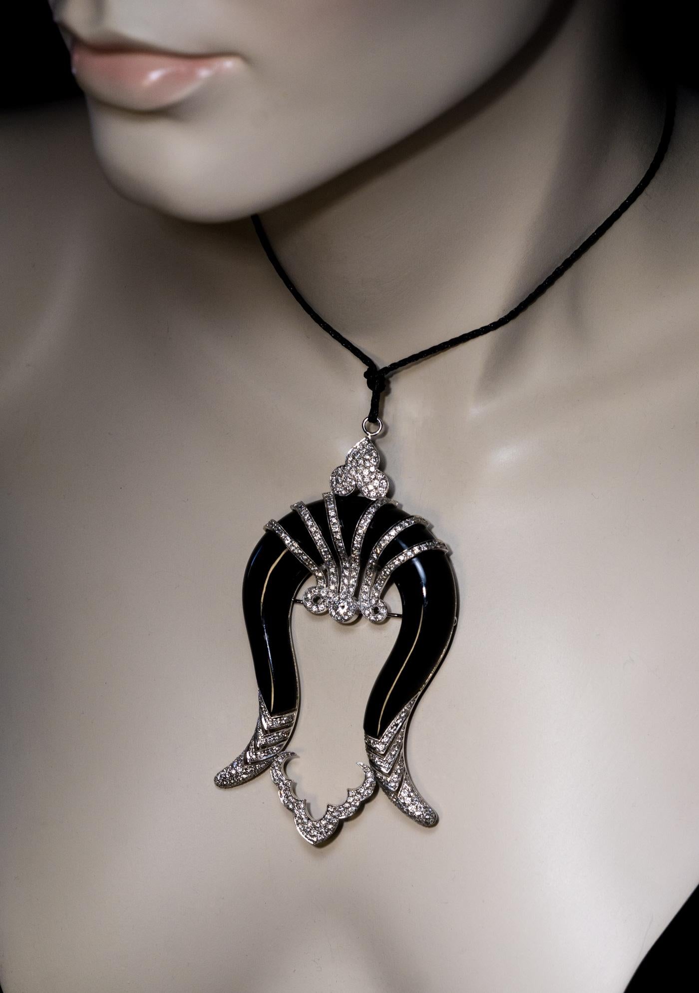 1930s
The pendant / brooch is designed in Art Deco taste as a silhouette of an Egyptian queen. The carved and polished black onyx depicts the hair, and the diamond and white 18K gold embellishments serve as the necklace, crown, and hair