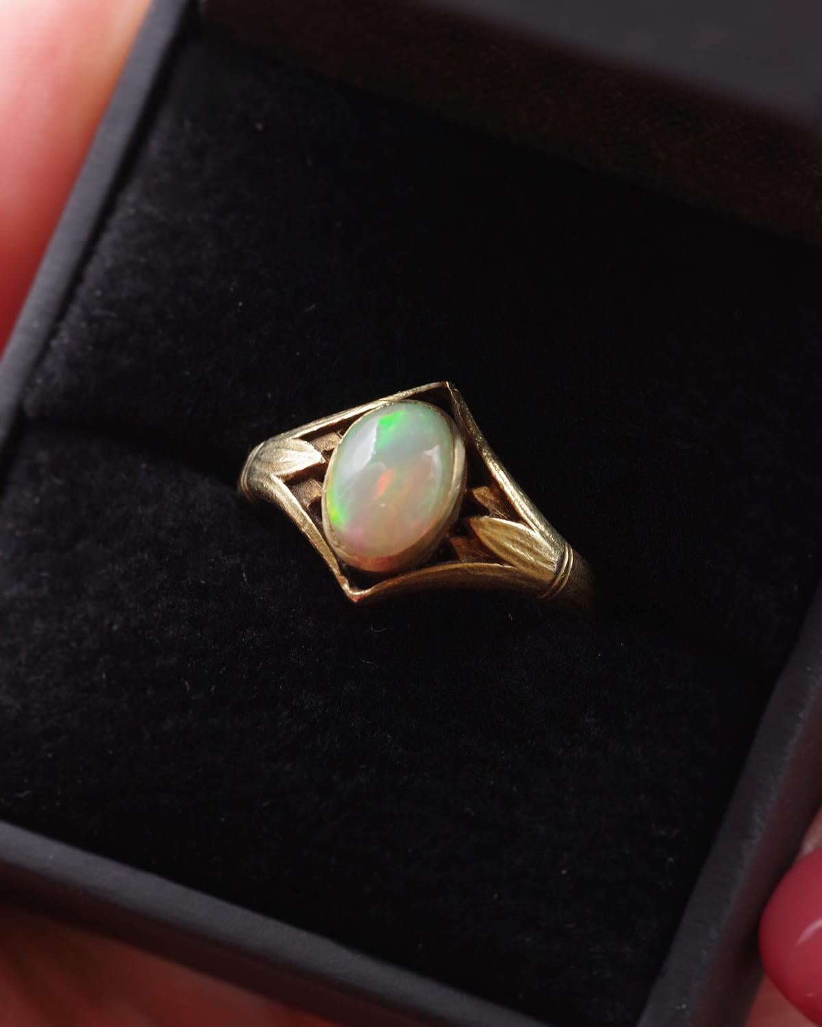 Egyptomania Arnould Opal Ring aus 18 Karat Gold. Jugendstilring im Egyptomania-Stil mit einem Opal im Cabochon-Schliff von ca. 1,15 ct in einer Lünettenfassung. Das Band ist an den Schultern mit Papyrus gemeißelt, Motive, die vom alten Ägypten