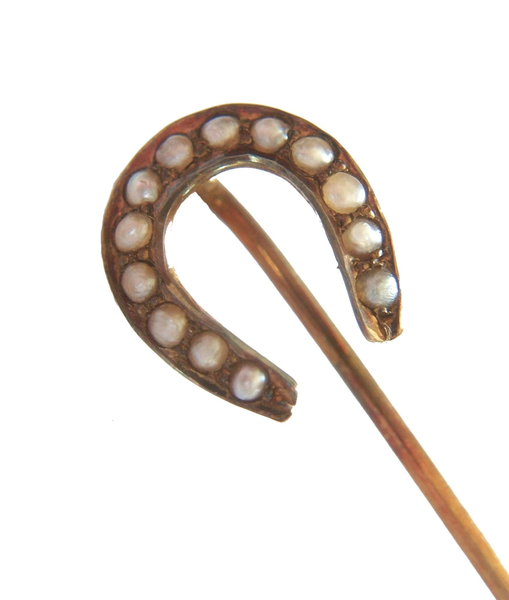 EHLERS & CO. - Victorian 14K yellow gold horseshoe stick pin - set with thirteen graduated seed pearls (1 cm. to 1.5 cm. diameter) - hand made - stamped 14K - E within a diamond hallmark - United States (New York) - circa 1900.

Excellent antique