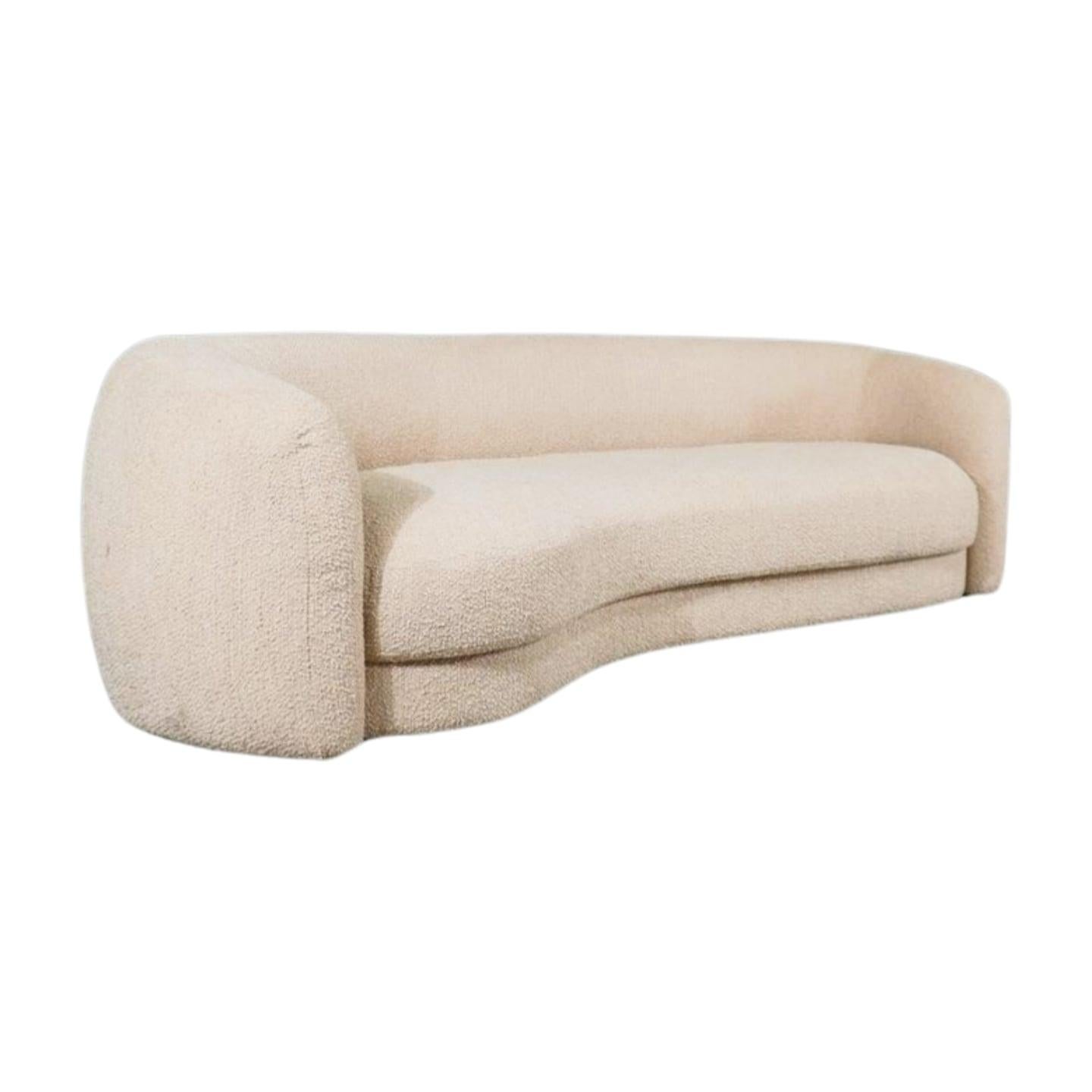 Elevate your living space with the chic and sophisticated Eichholtz Blaine Curved Sofa. Upholstered in elegant beige boucle fabric, this sofa features a curved silhouette and sleek metal legs for a modern look. Its generous seating space and plush