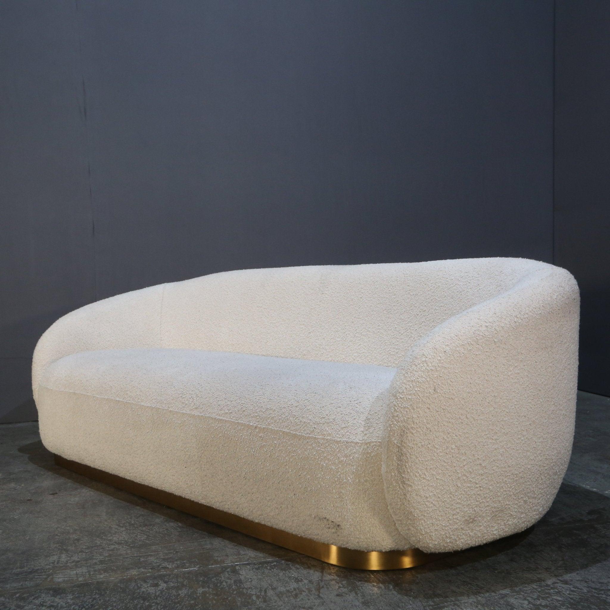 The Eichholtz Brice White Bouclé Sofa brings a touch of contemporary elegance to any living space. Upholstered in luxurious white bouclé fabric, this sofa offers a soft, textured surface that feels as inviting as it looks. The curved silhouette