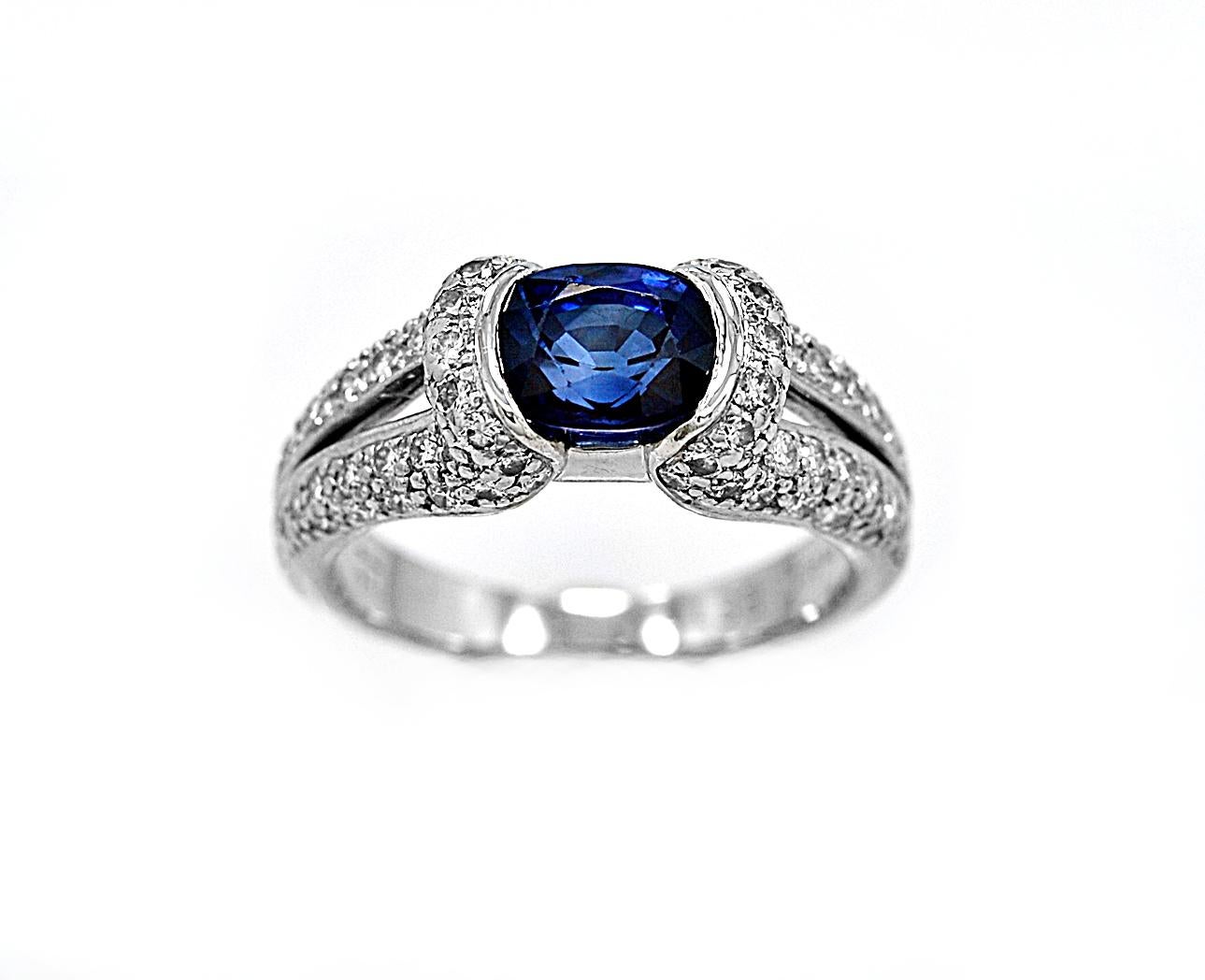 An estate engagement-fashion ring created by the well-known maker Eichhorn which features a 1.75ct. apx. beautiful blue oval sapphire with 1.00ct. apx. T.W. of accenting diamond melee on a split shank on each side of the center diamond. A