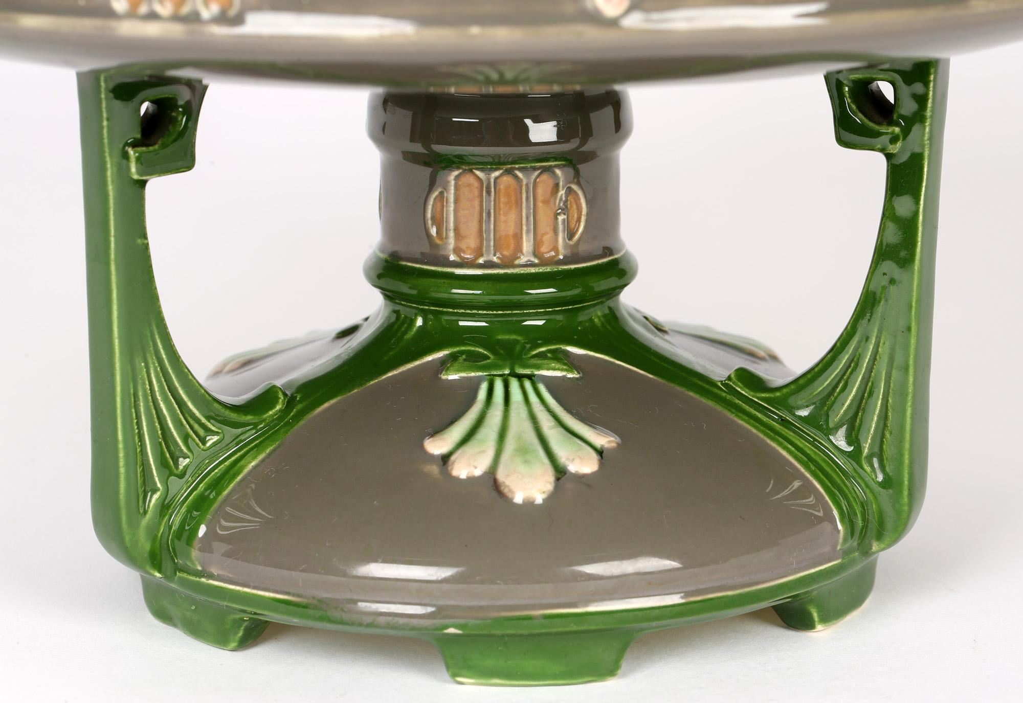 A striking and exceptional Eichwald secessionist Art Nouveau pedestal centerpiece Majolica pottery bowl dating from the early 20th century. The shallow rounded bowl shaped top stands mounted on a pedestal base supported on six feet with a domed