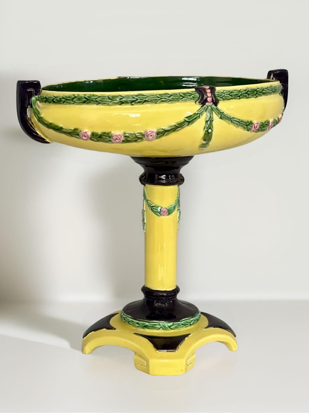 Antica ciotola con piedistallo in maiolica dipinta a mano con smalti gialli, rosa, verdi e neri da Eichwald, inizio XX secolo. Presenta elementi decorativi classici dell'Art Nouveau con intricati motivi floreali e fogliati in rilievo e dettagli