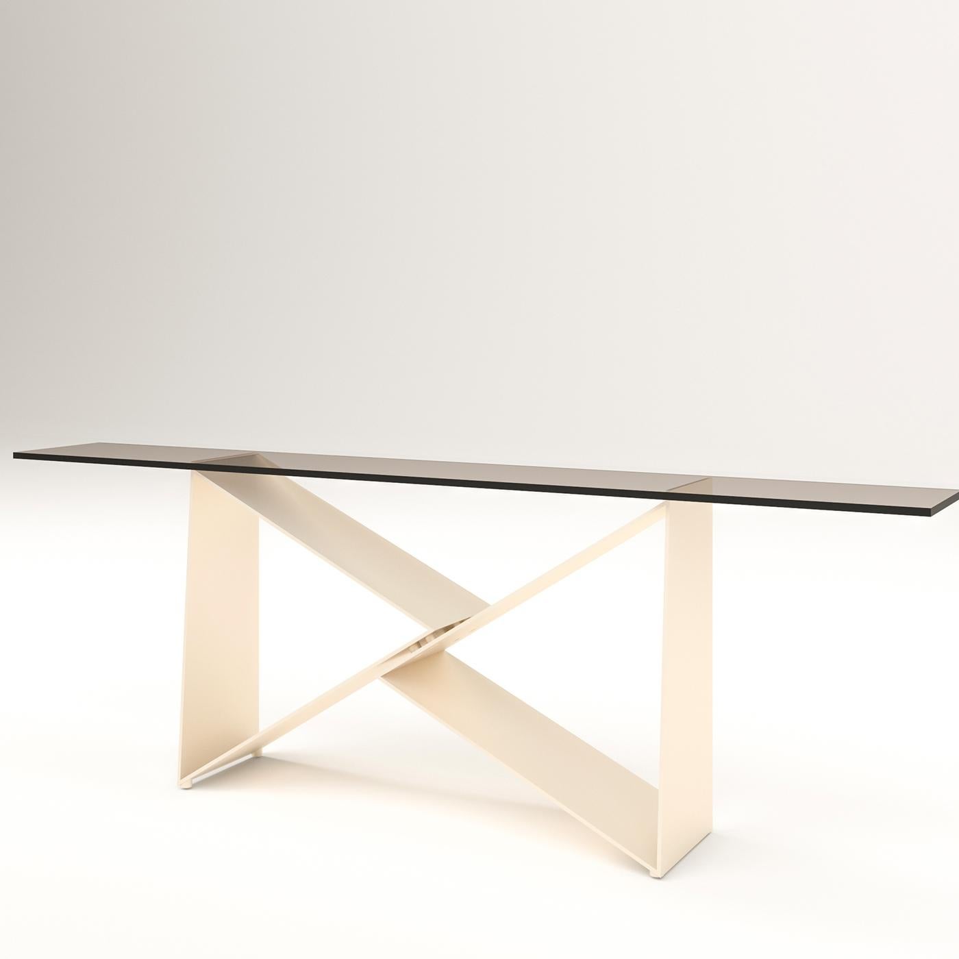 Table with base in milled solid iron blade, worked by hand. The shelf is available in different versions. Presented here with base in gold-titanium finish and shelf in smoked crystal.