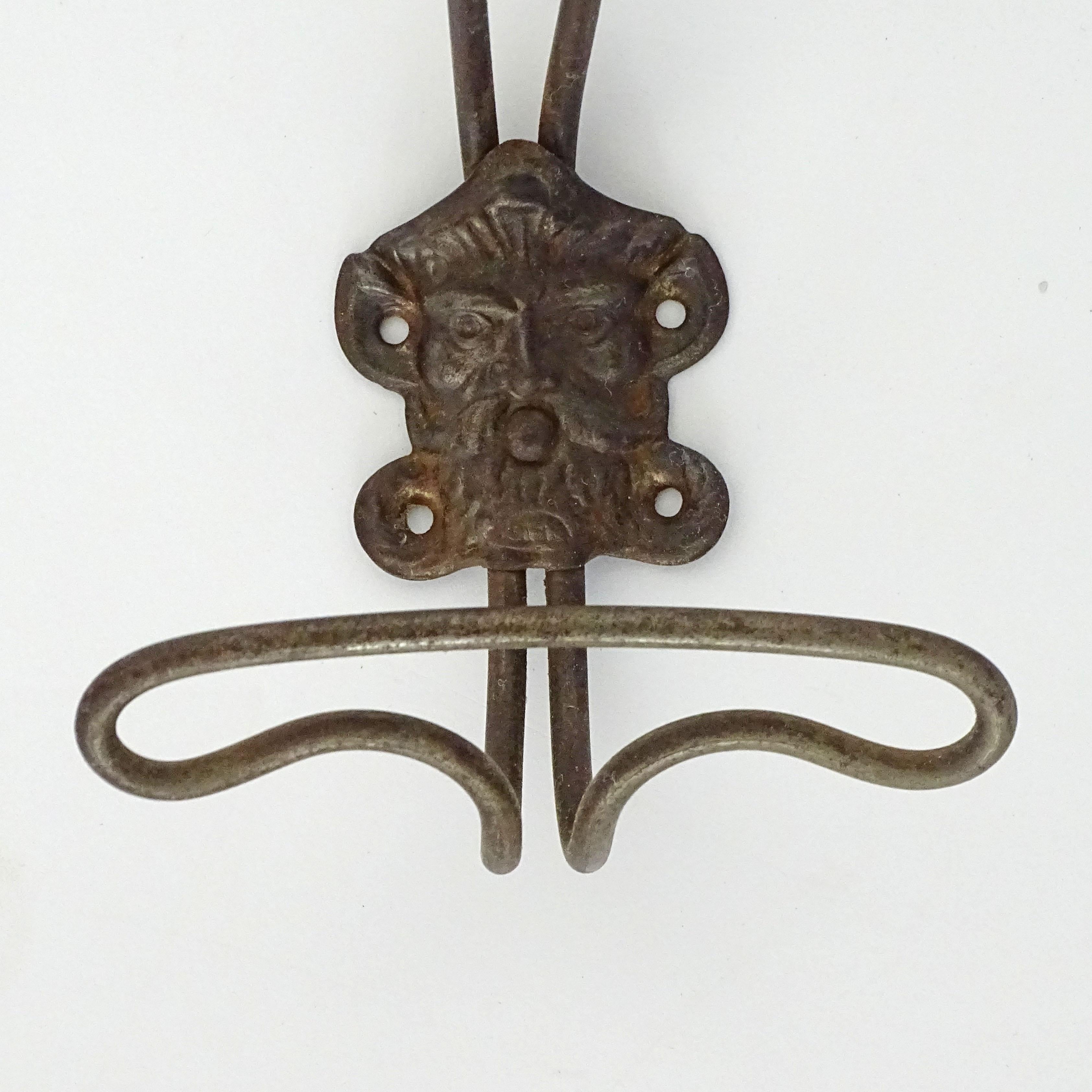 Eight 19th Century Italian metal wall coat hangers with a classic male face. In Good Condition For Sale In Milan, IT