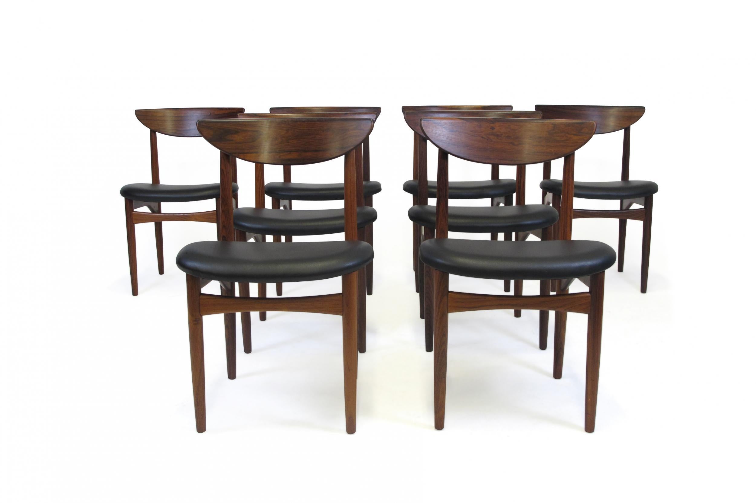 Danish dining chairs designed by Kurt Ostervig for K.P Møbelfabrik, Denmark. The chairs are handcrafted of solid Brazilian rosewood frames with sculpted backrests and newly upholstered in black leather. The wood used is of the finest rosewood, which