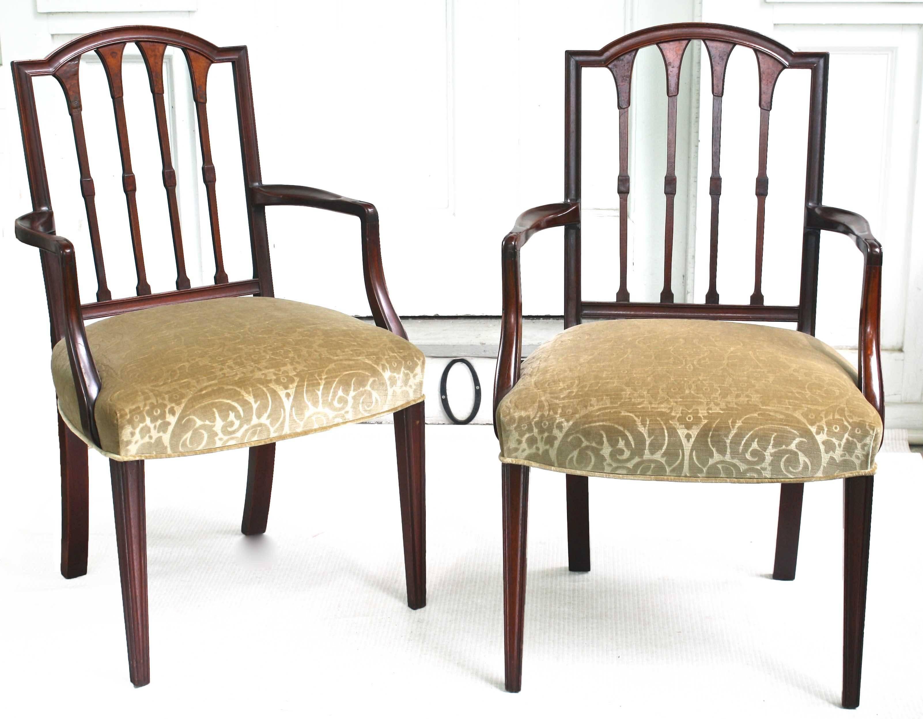 Two solid carved mahogany armchairs and six side chairs. Finely detailed including walnut burl veneers applied to the back-spindle vasiform tops. American Centennial in spirit, believed to be of New England origin. This set of eight chairs may be