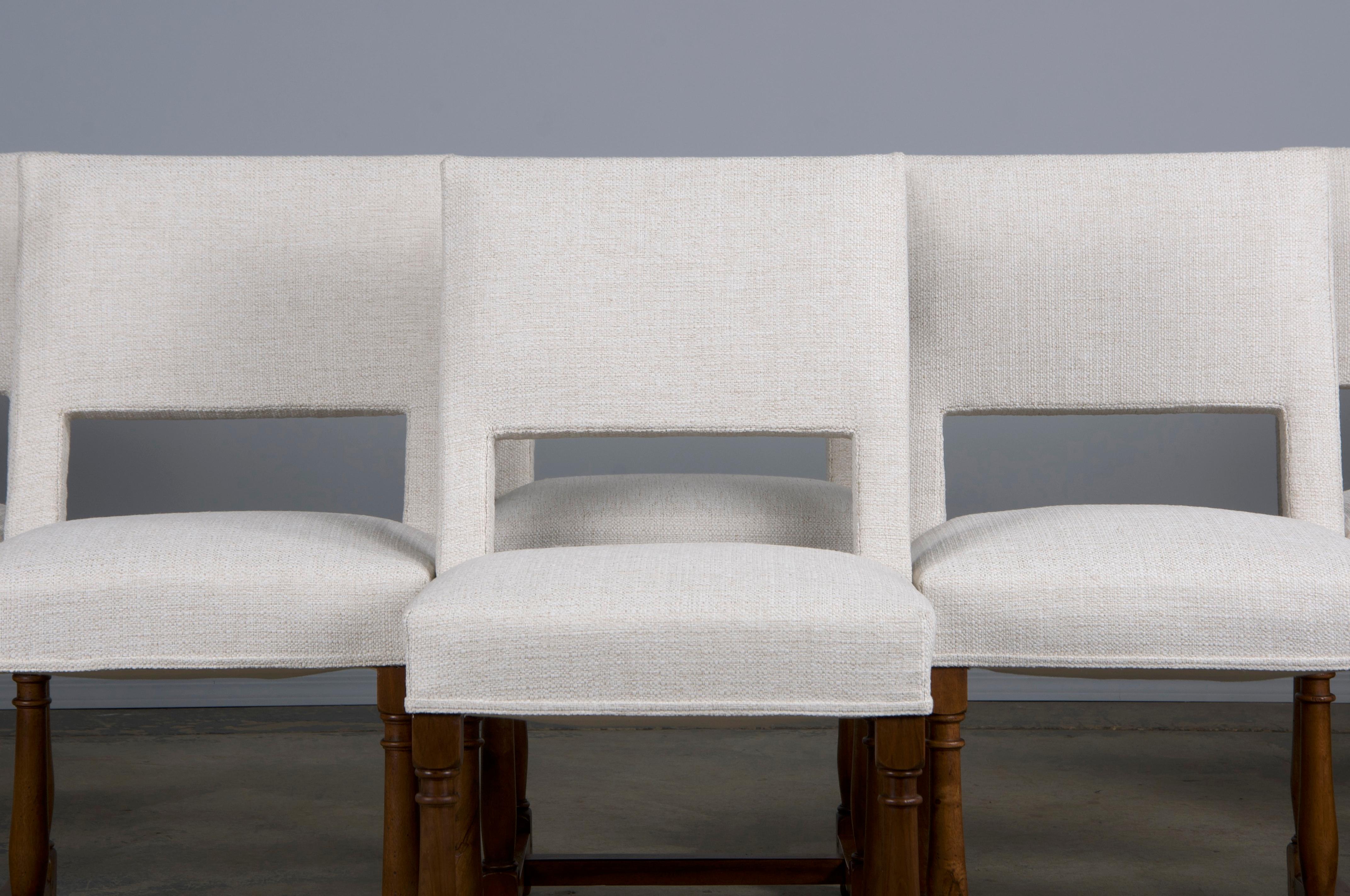 An exquisite set of eight late 19th-century French dining chairs, crafted in the Louis XIII style and sourced from Provence, France. Meticulously handcrafted from solid walnut, each chair features a stately square-shaped backrest. The chairs have