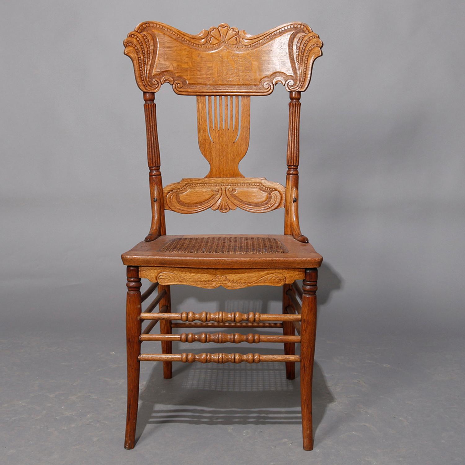A set of 8 dining chairs by Heywood Wakefield offer pressed scroll and foliate backs over caned seats and raised on turned legs, oak pressed back Heywood Wakefield dining chairs

Measures: 40