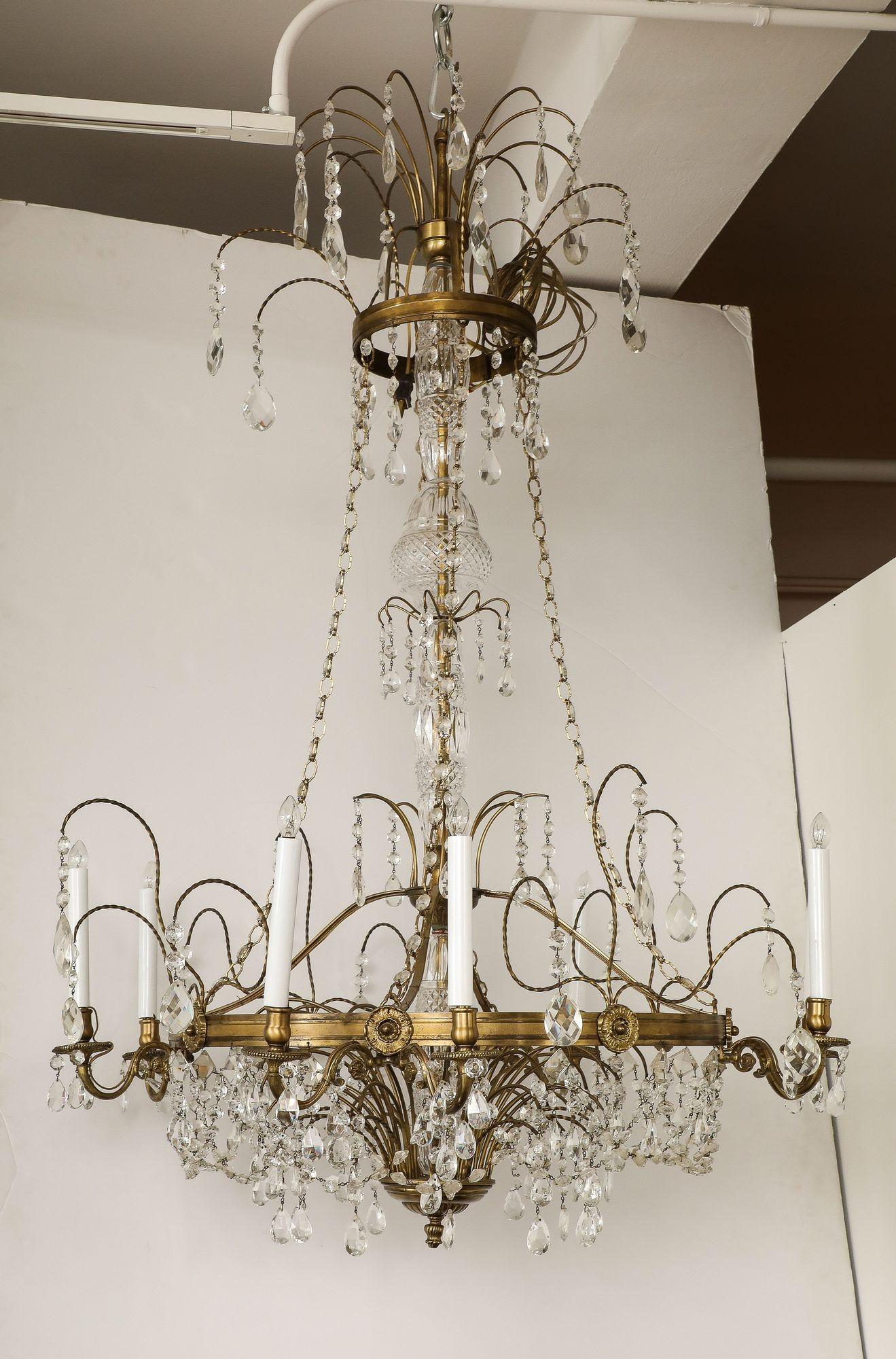 Ce lustre français exquis du milieu du XXe siècle apporte une élégance intemporelle à tout espace grâce à son mélange harmonieux de laiton et de cristal. Avec ses huit bras gracieux ornés de délicates perles de verre, elle projette une lumière