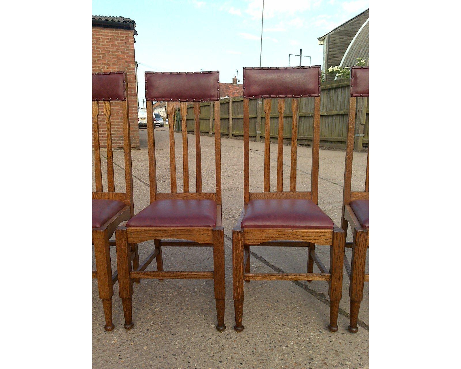 A set of eight Glasgow style high back oak dining chairs consisting of two armchairs and six singles with professionally re upholstered leather padded seat and head rests.
The last image is of one of the armchairs beside a single chair before they