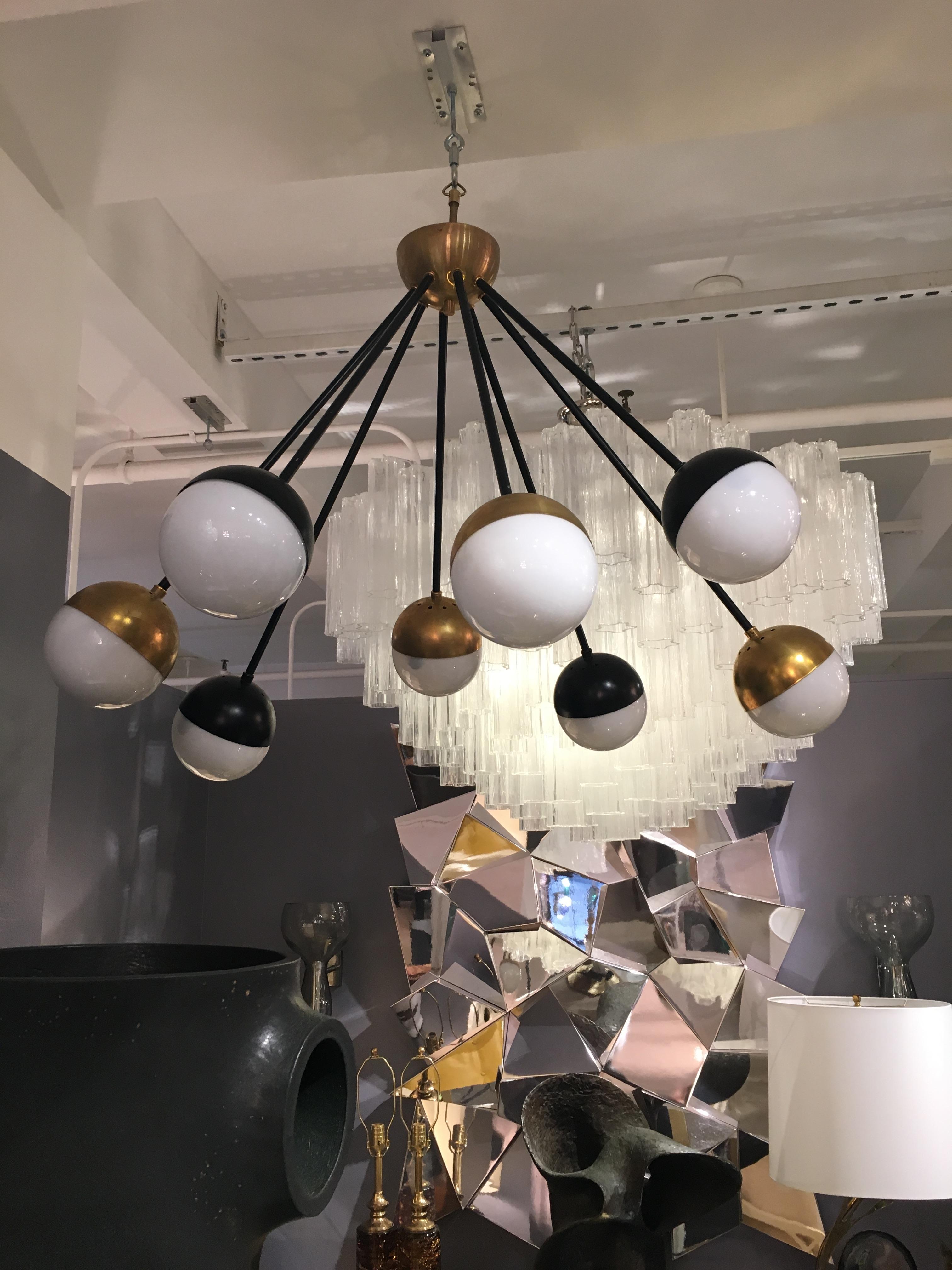 An eight-arm chandelier in brass and black with white globes by Stilnovo.

Italian, Circa 1960's

In stock.

UL Listing Service is available upon request.