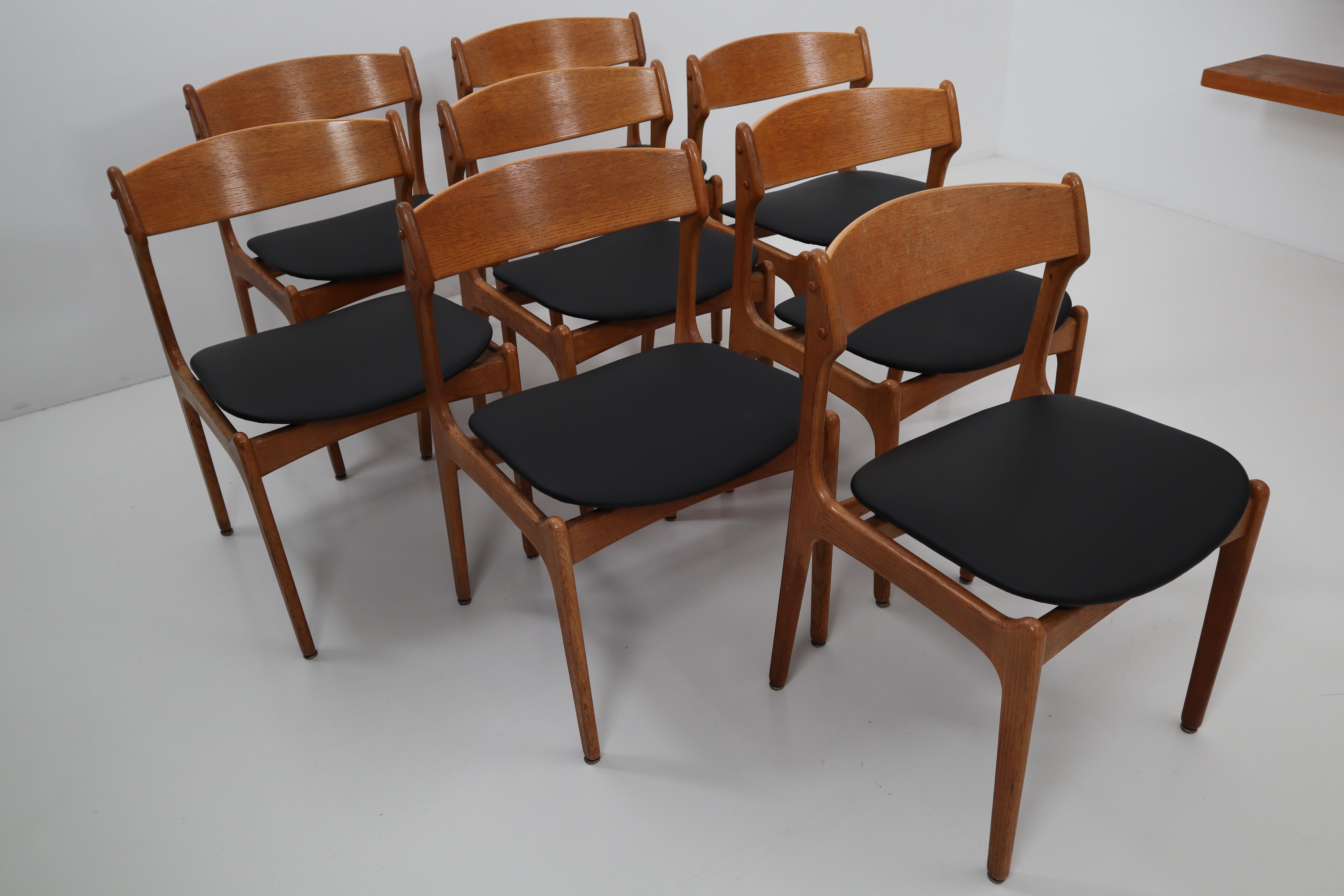 Set of eight dining room chairs designed by Erik Buck, Denmark and produced by O. D. Mobler. The seat frame is made of solid oakwood, the seats are newly covered with matte black leather. The dining room chairs are labeled underneath. The dining