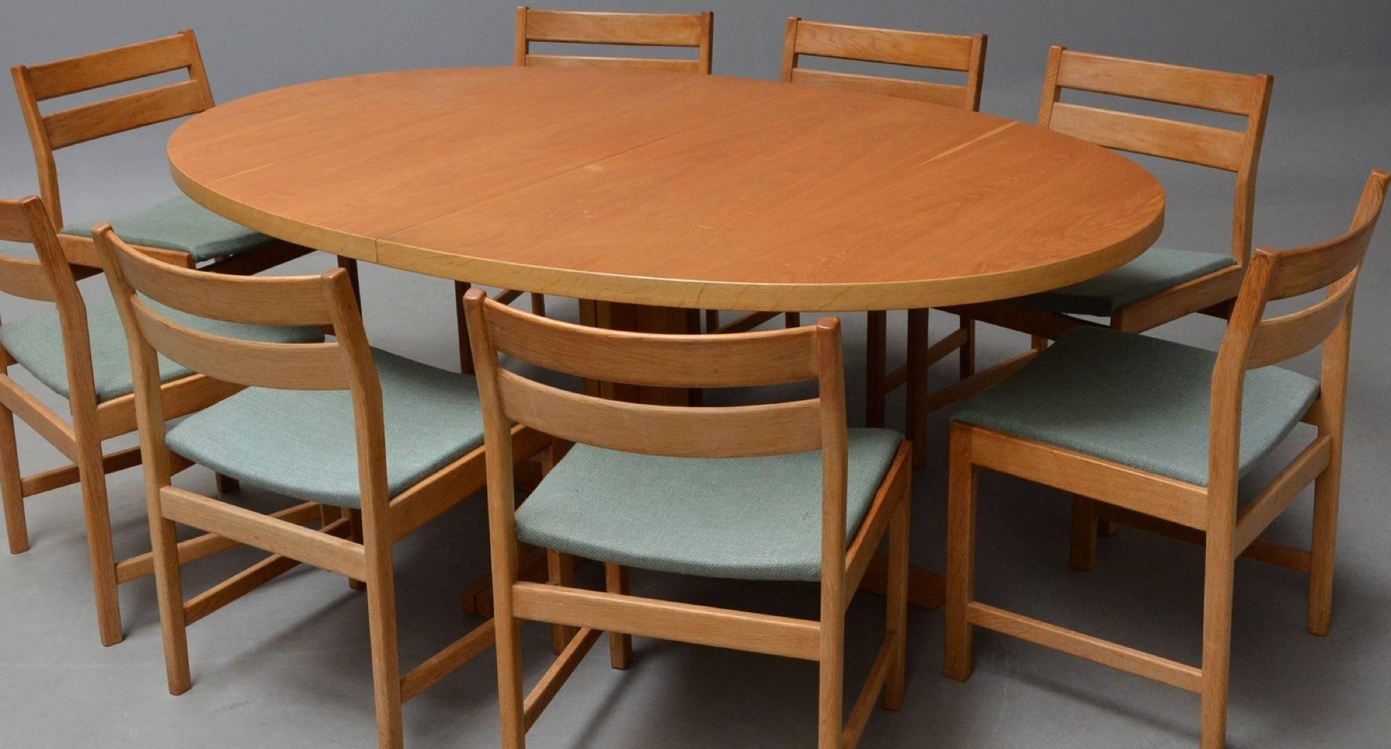 Set of eight chairs with corresponding table by Kurt Stervig for KP Furniture. Dining table with two additional plates and eight attached chairs. Made in oak. Measures: Table H. 72, L. 190/290., B. 122 cm.