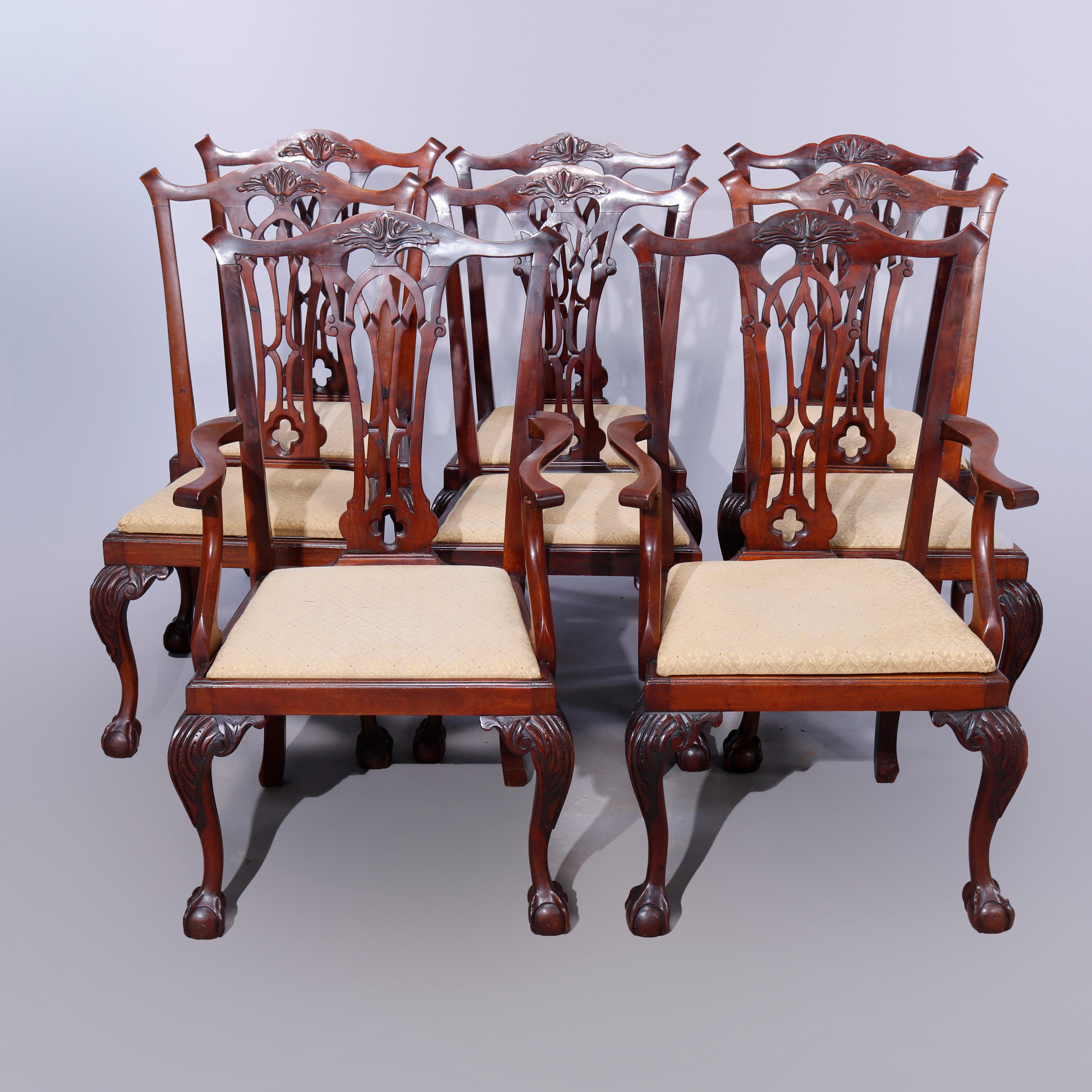 A set of eight Chippendale style dining chairs offer mahogany construction with shaped rails having carved foliate central element over reticulated slat backs, raised on cabriole legs with stylized acanthus knees and terminating in claw and ball