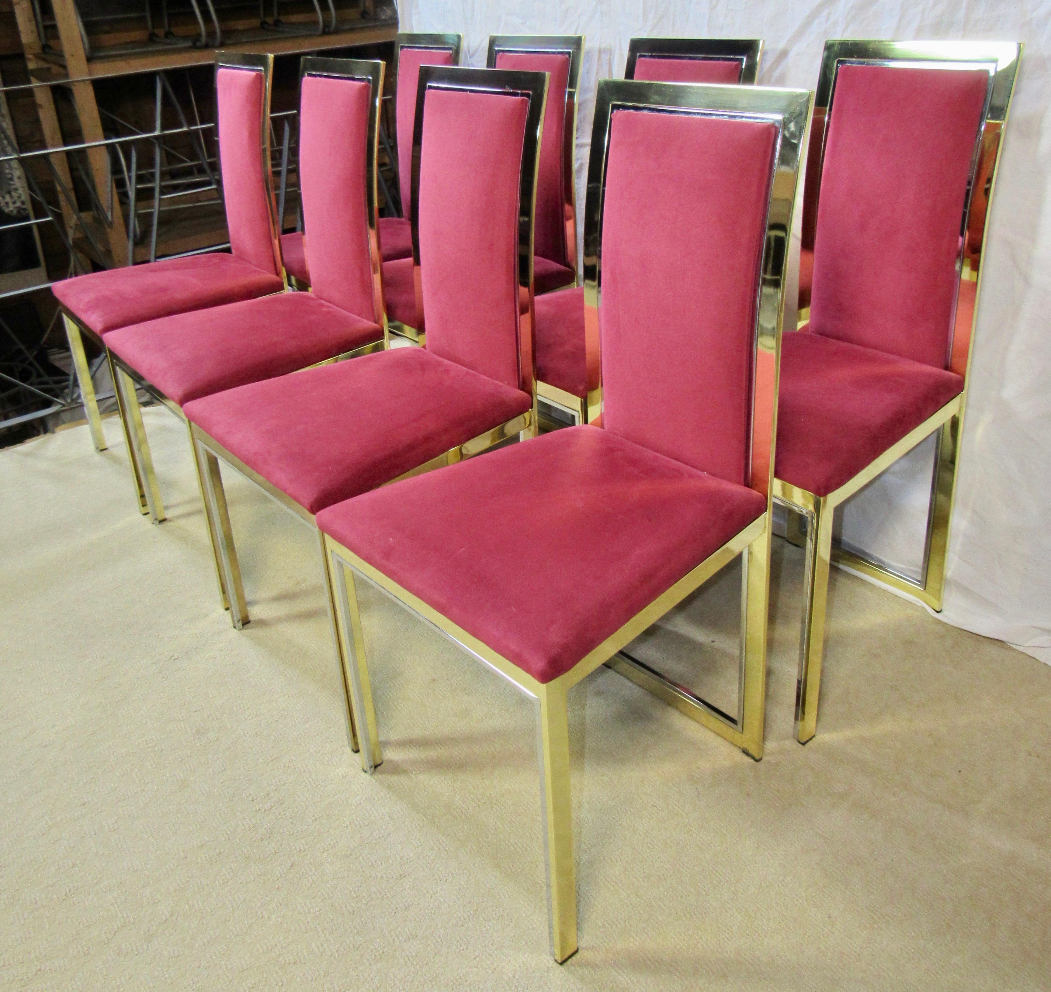 Eight polished brass framed dining chairs attributed to Romeo Rega with inset polished aluminum tube details. 
The mixed metal framing adds a dramatic note to the chairs' appearance. 
The vintage upholstery is a raspberry Alcantara, a Japanese