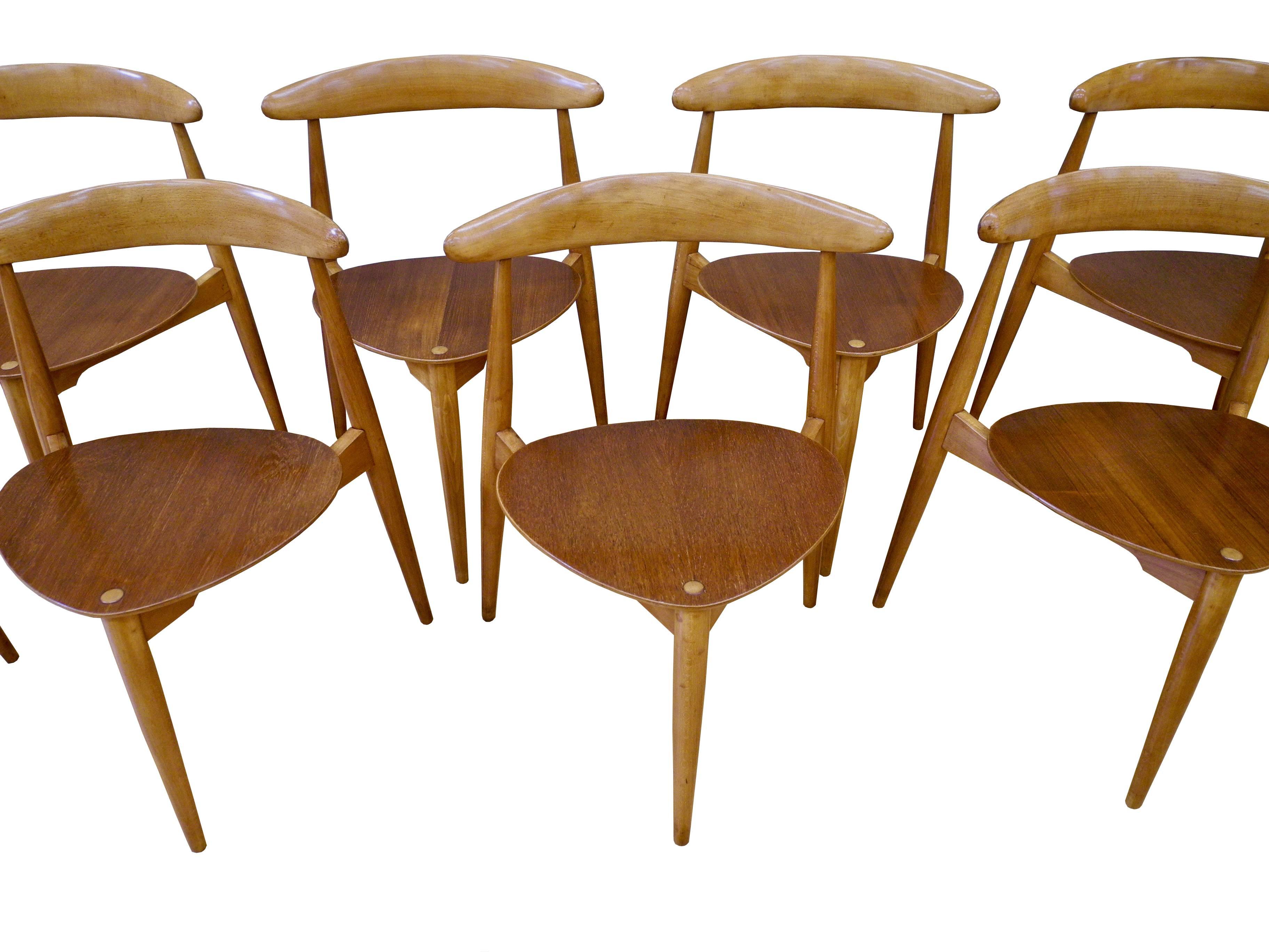 This set of eight Danish modern stacking dining chairs are made of teak and beech. The 